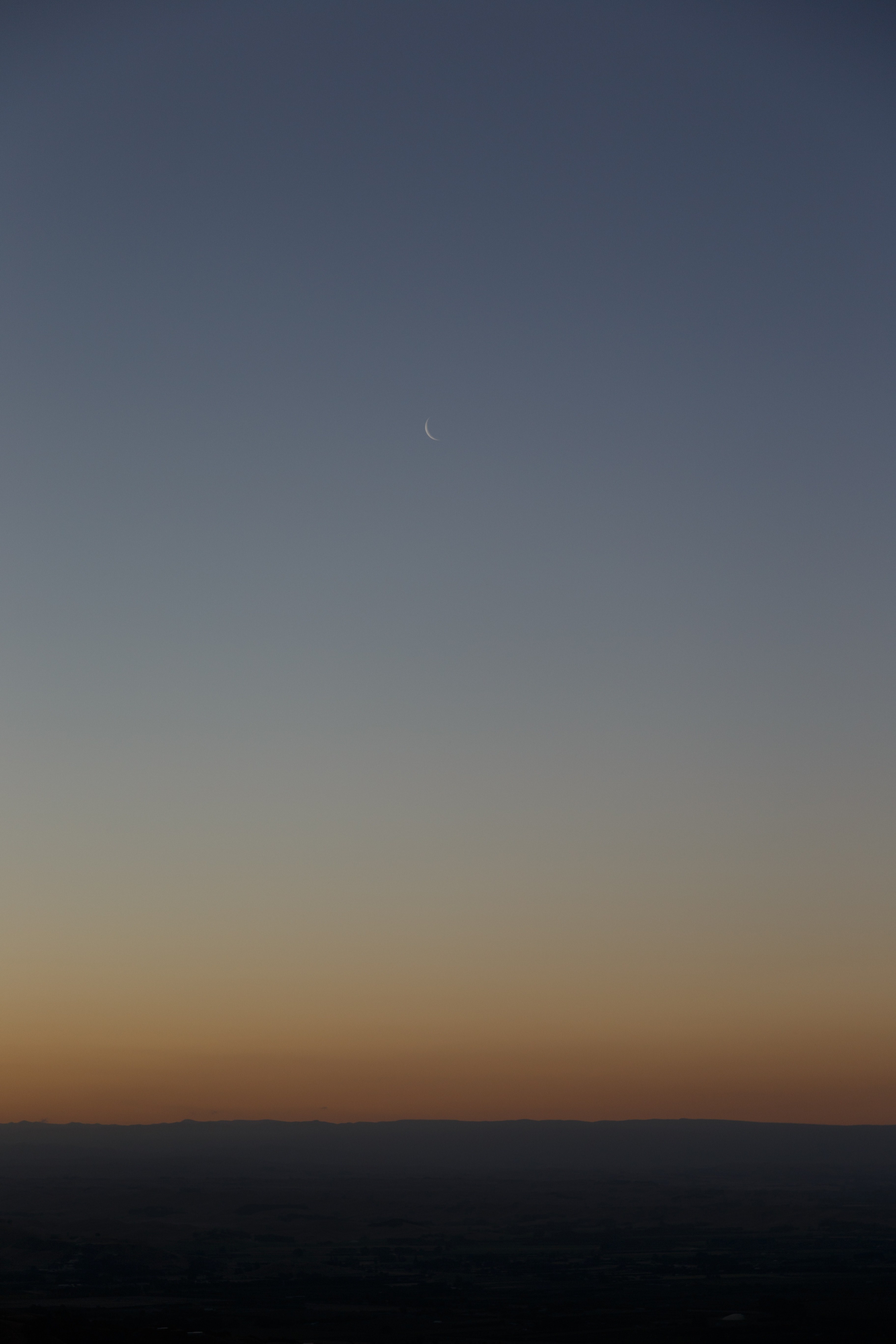 the moon like a sliver hangs on a pale blue sky at dusk over a spare landscape, moon over a spare landscape 4k, Phone HD Wallpaper