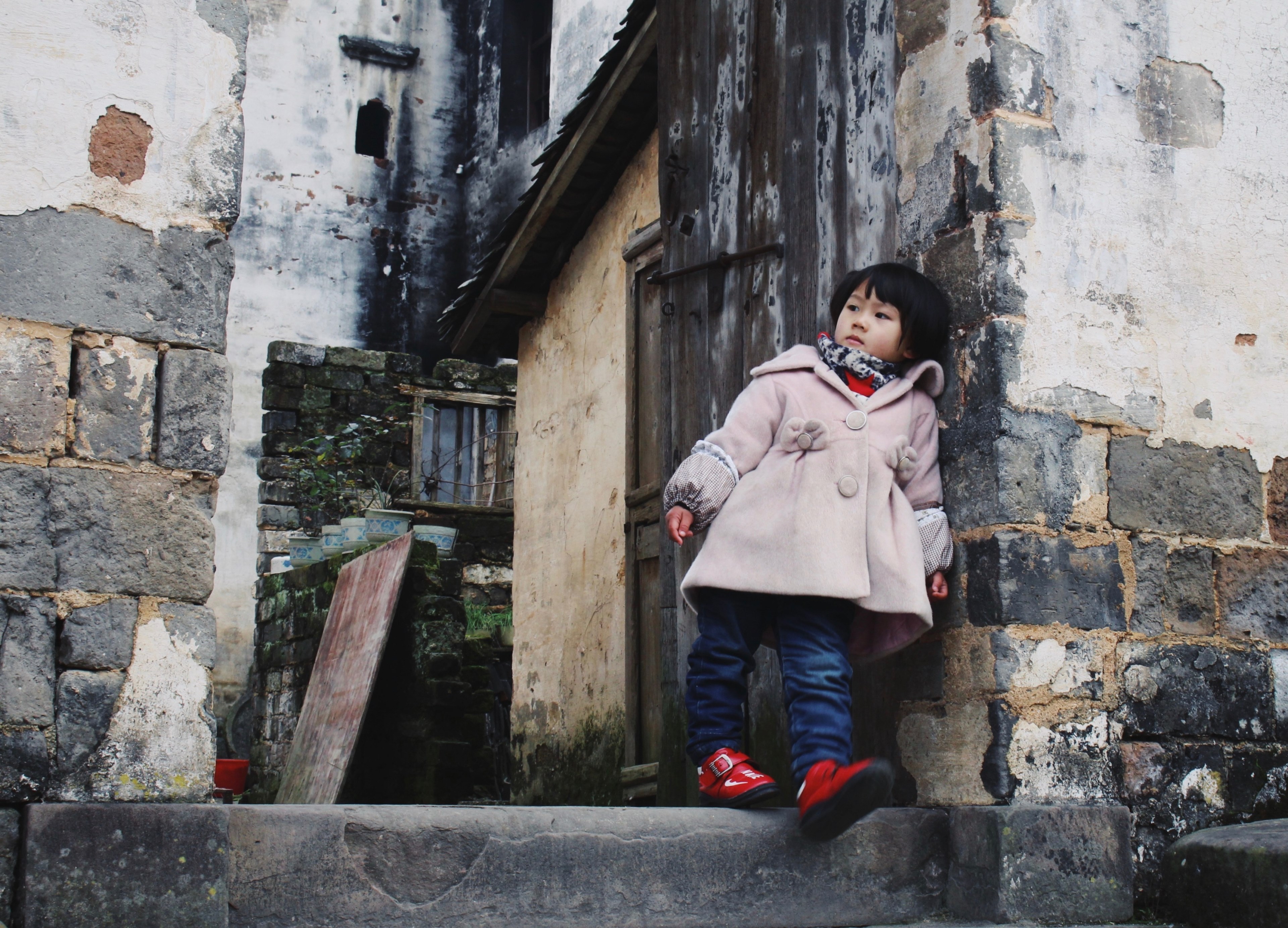 cute young girl in a winter coat leans against a brick building, little girl leaning 4k, HD Wallpaper