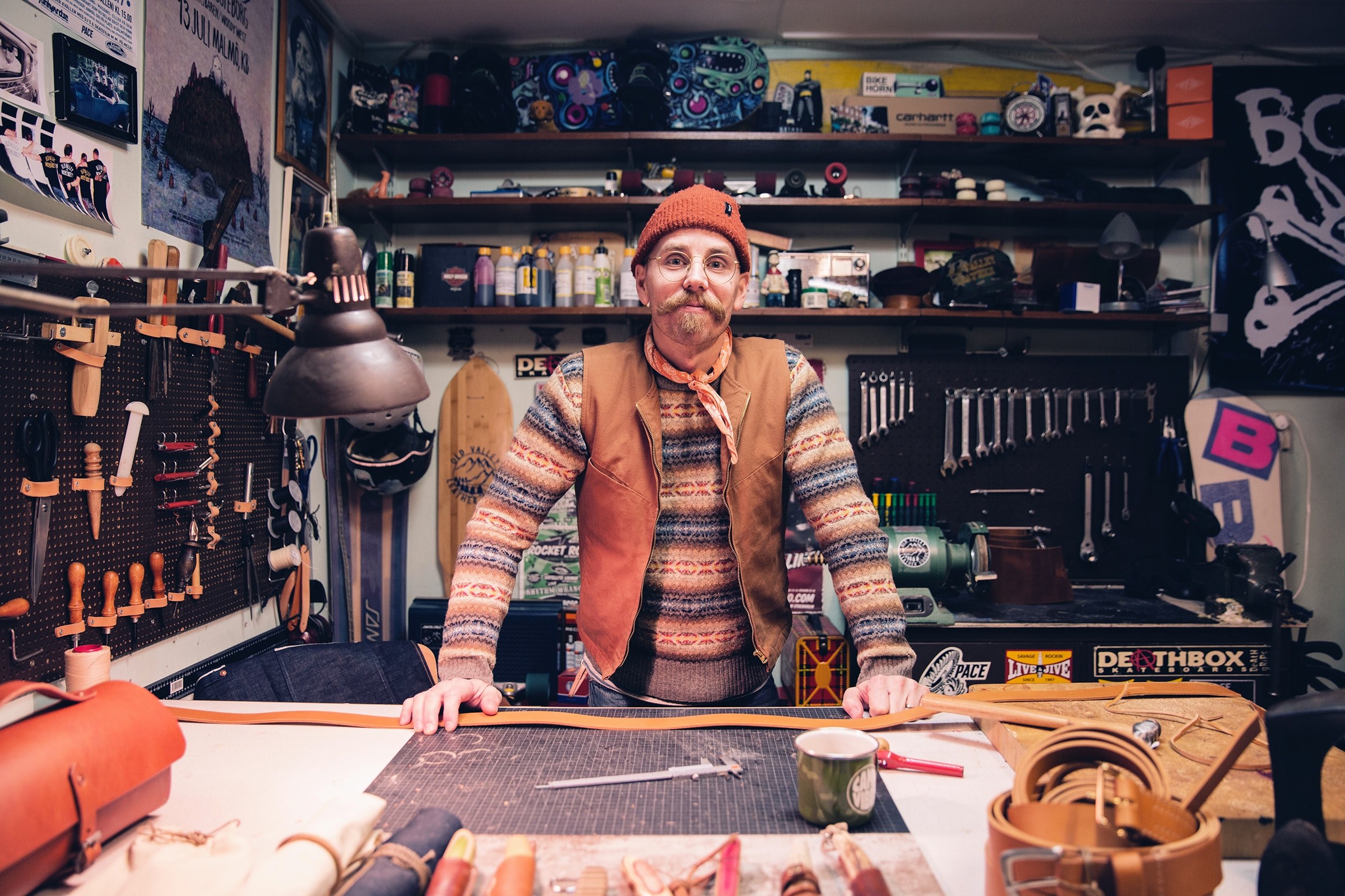 a middle aged man in a knit cap behind a workbench in a workshop, christer old valley leather goods 4k, HD Wallpaper