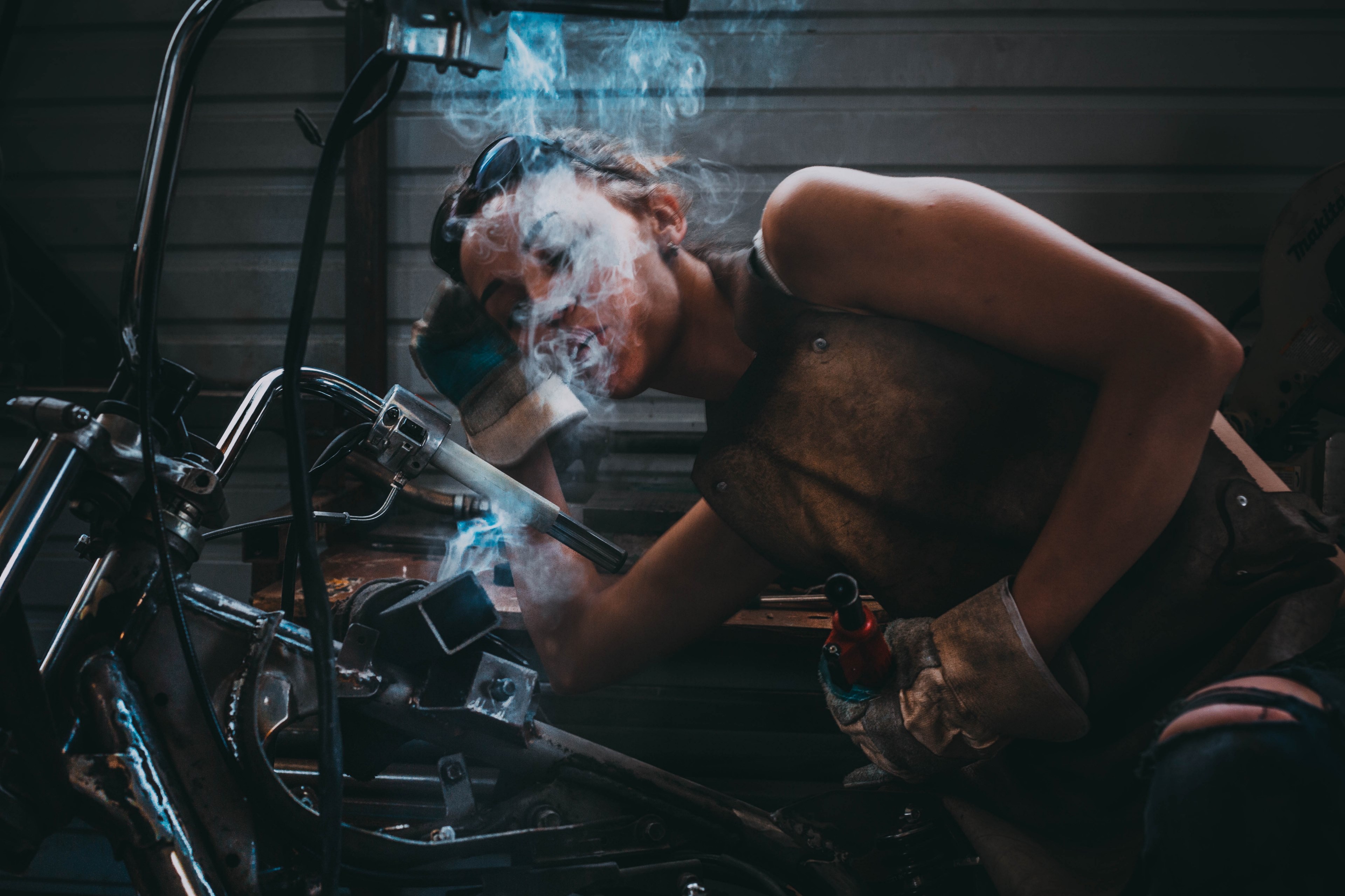 woman working on a motorbike while smoking a cigarette in bishkek, do not judge the girl on the pads from gucci_ par2 4k, HD Wallpaper