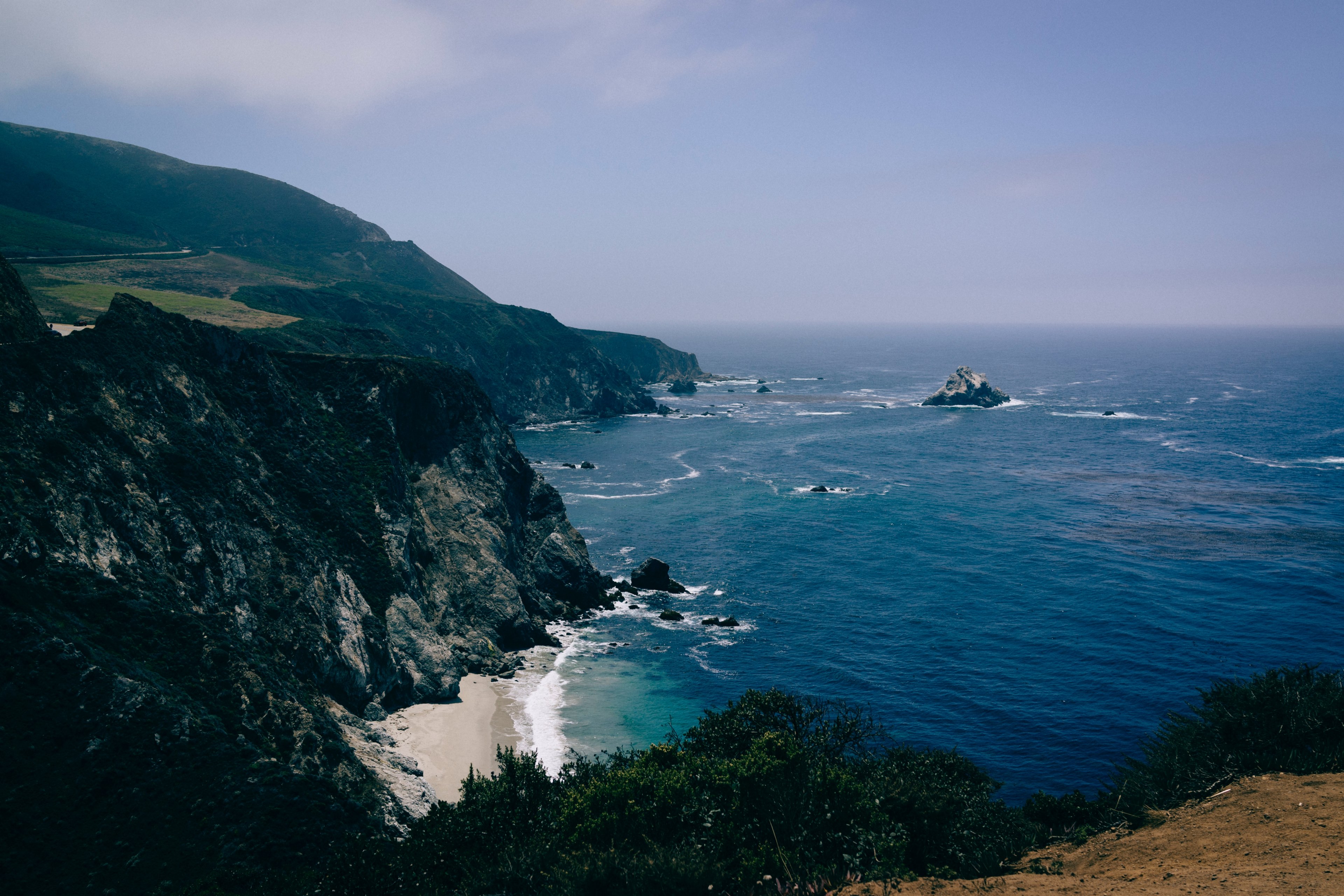 a dim shot of craggy hills over a deep blue sea, rocky coastline at big sur ca 4k, HD Wallpaper