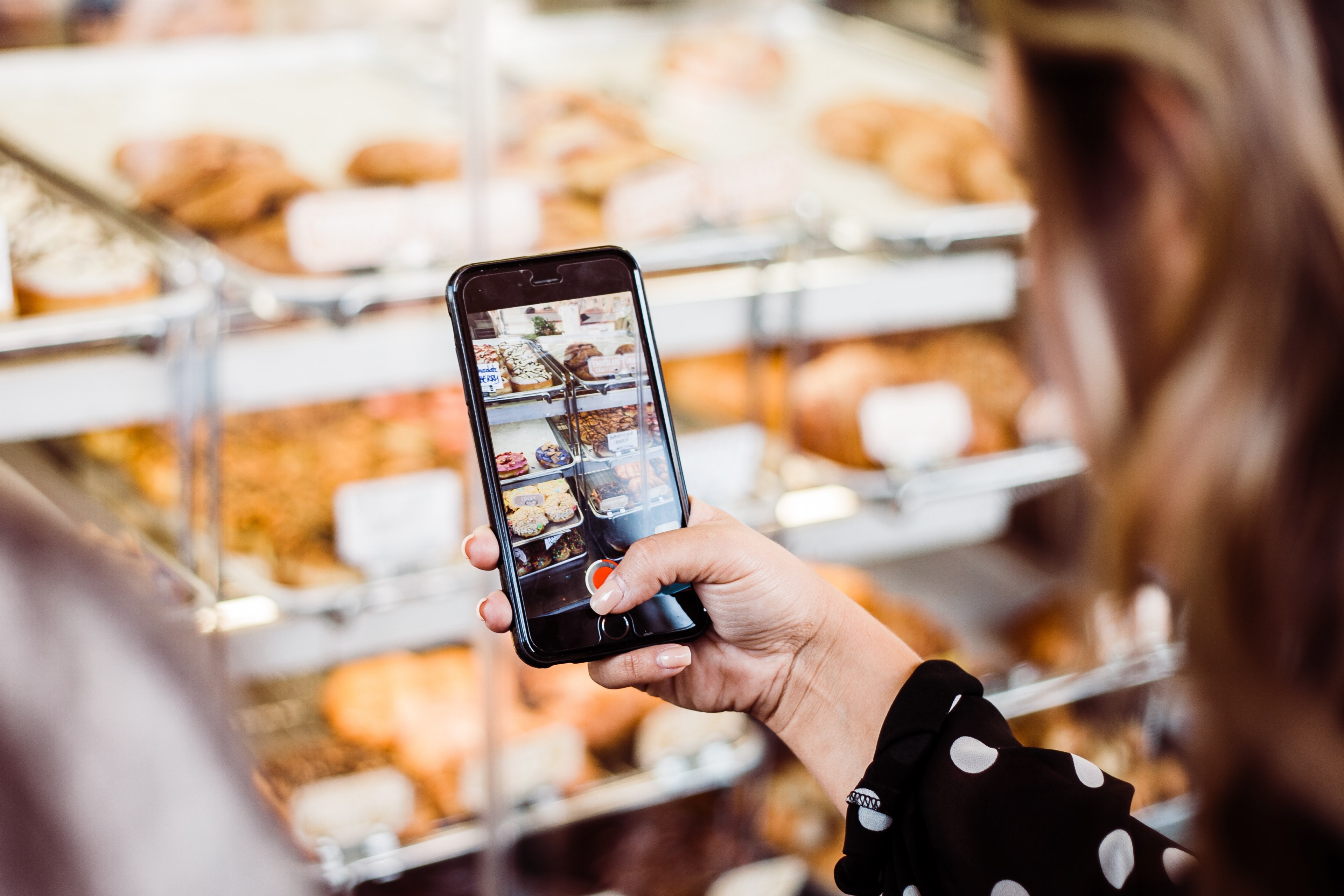 a person taking a photo of donuts at california donuts with their iphone cellphone, iphone bakery video 4k, HD Wallpaper
