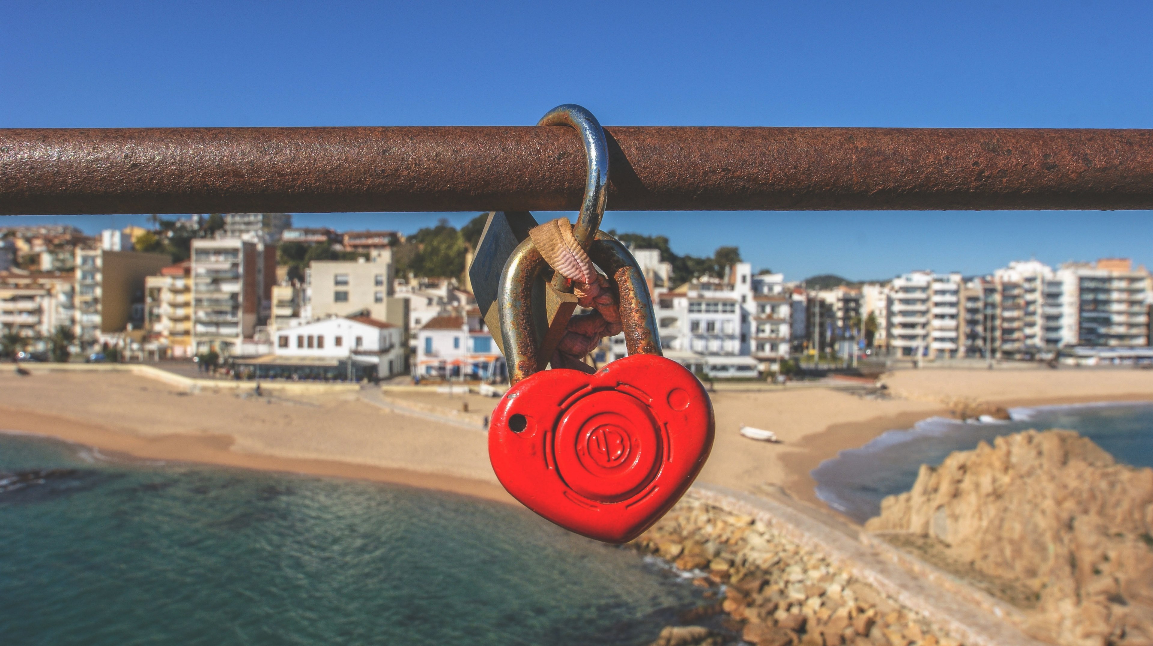 a red heart shaped padlock on a bridge rail overlooking a sandy beach, love padlock 4k, HD Wallpaper