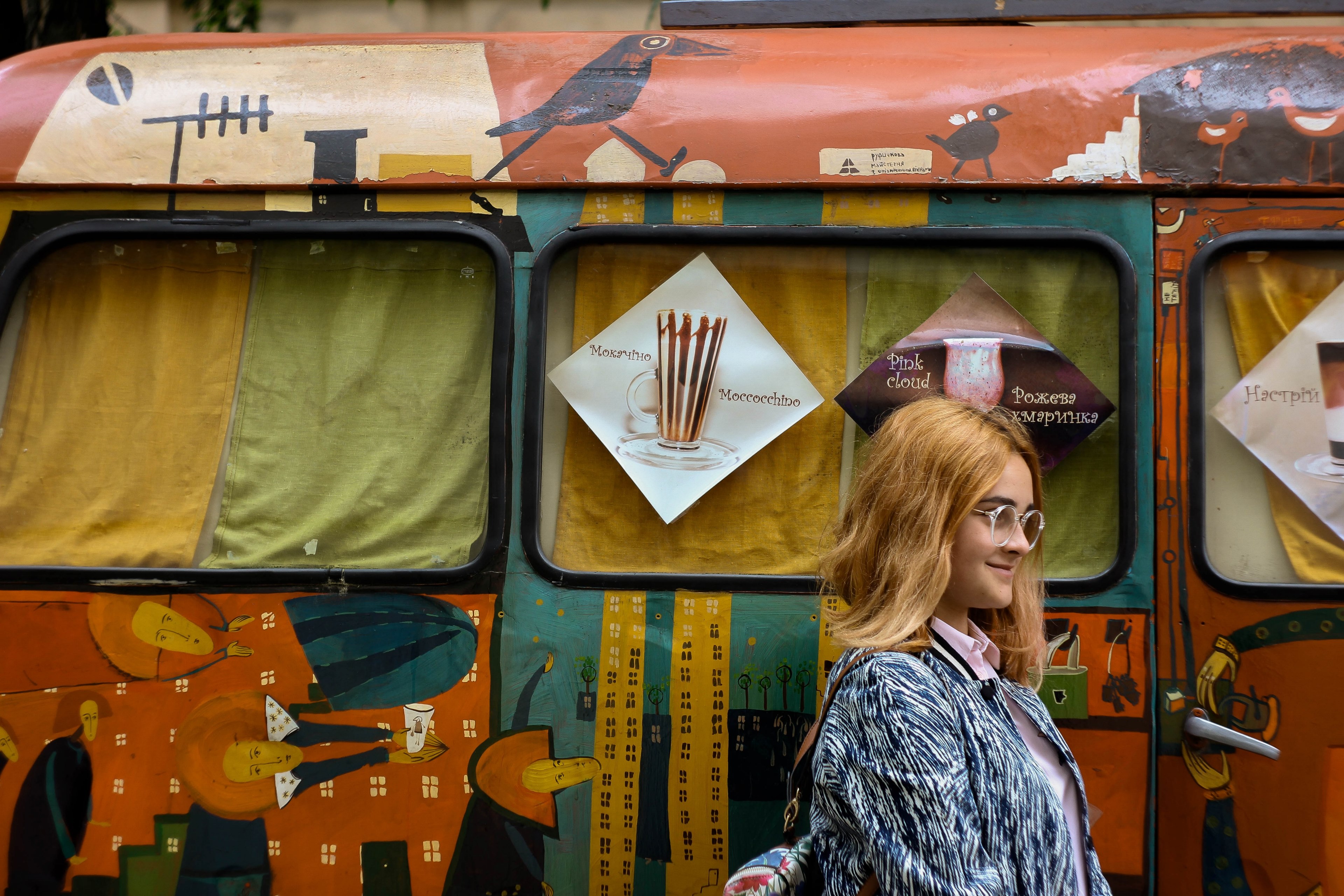 a stylish smiling woman in glasses walks by a bright intricately decorated bus, woman with decorated bus 4k, HD Wallpaper