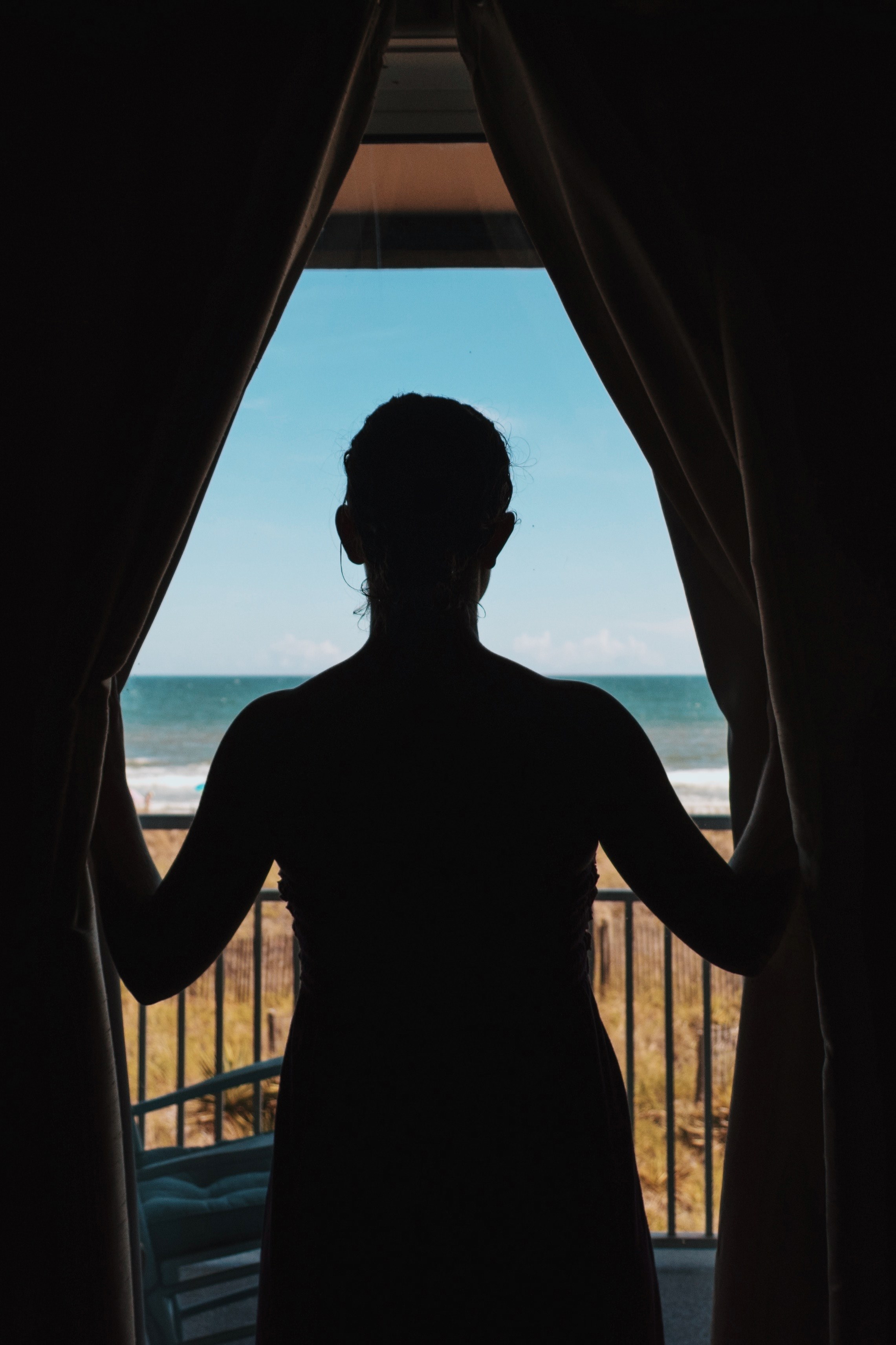 silhouette of the person looking through balcony curtains on the ocean isle beach coast, relief 4k, Phone HD Wallpaper