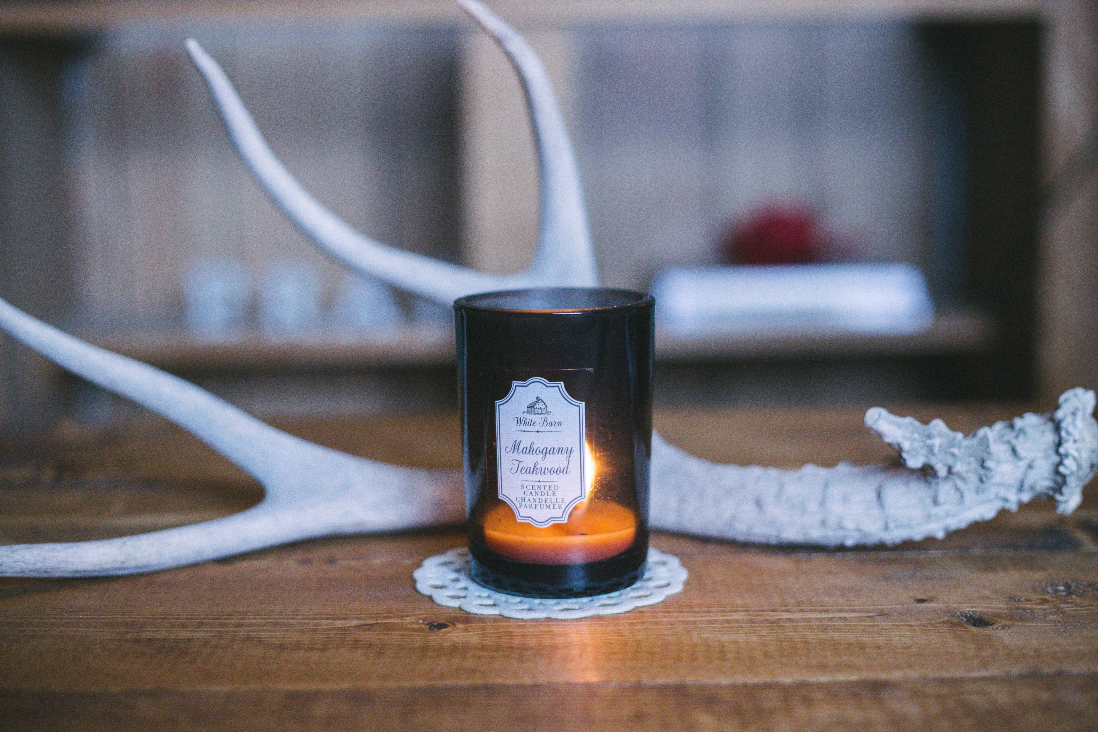 a candle on top of a table with an antler decoration behind it, _candle and antler 4k, HD Wallpaper