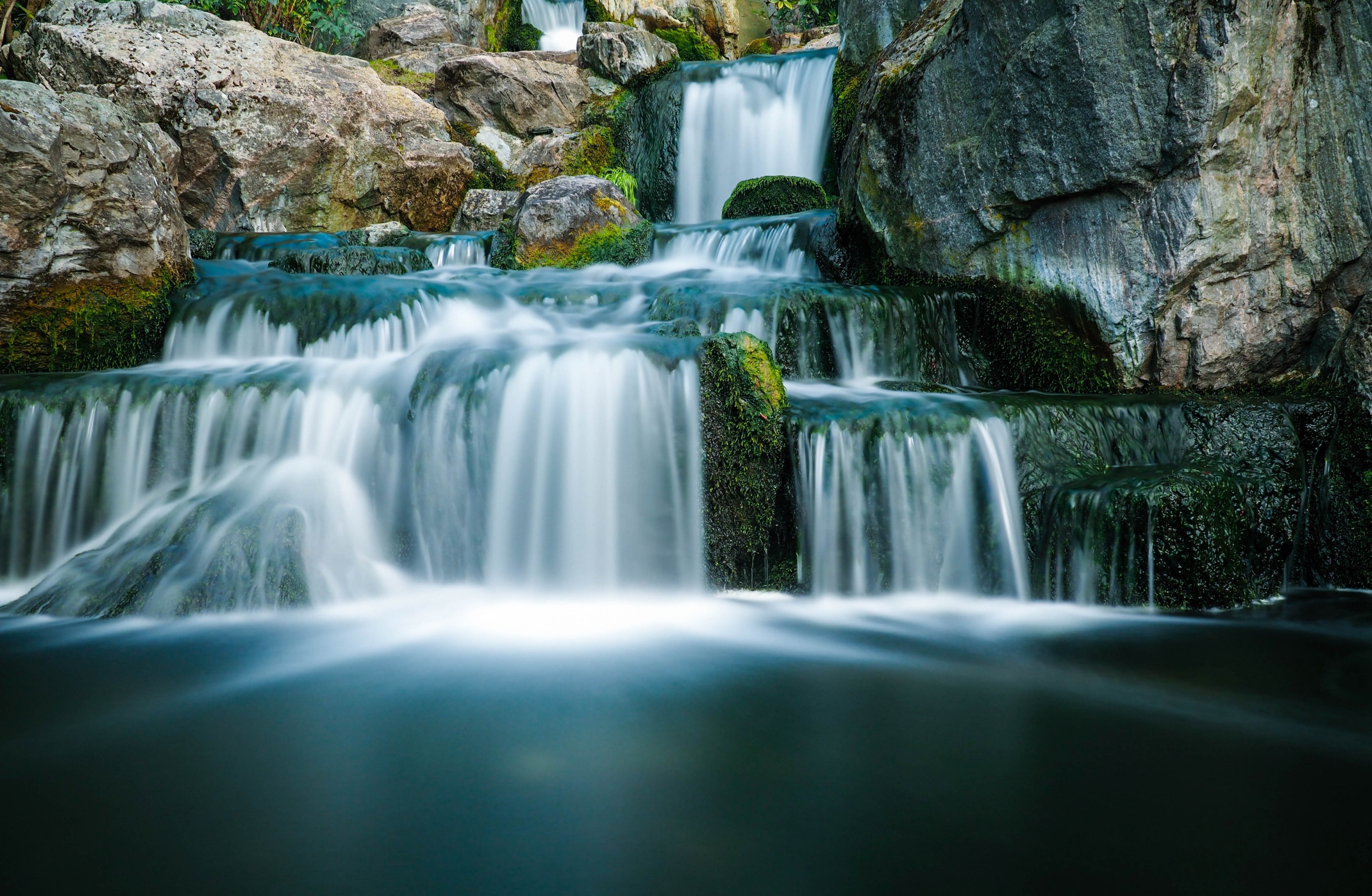 a staggered waterfall in motion flowing through a mossy rock mountain in holland park, the japanese garden 4k, HD Wallpaper