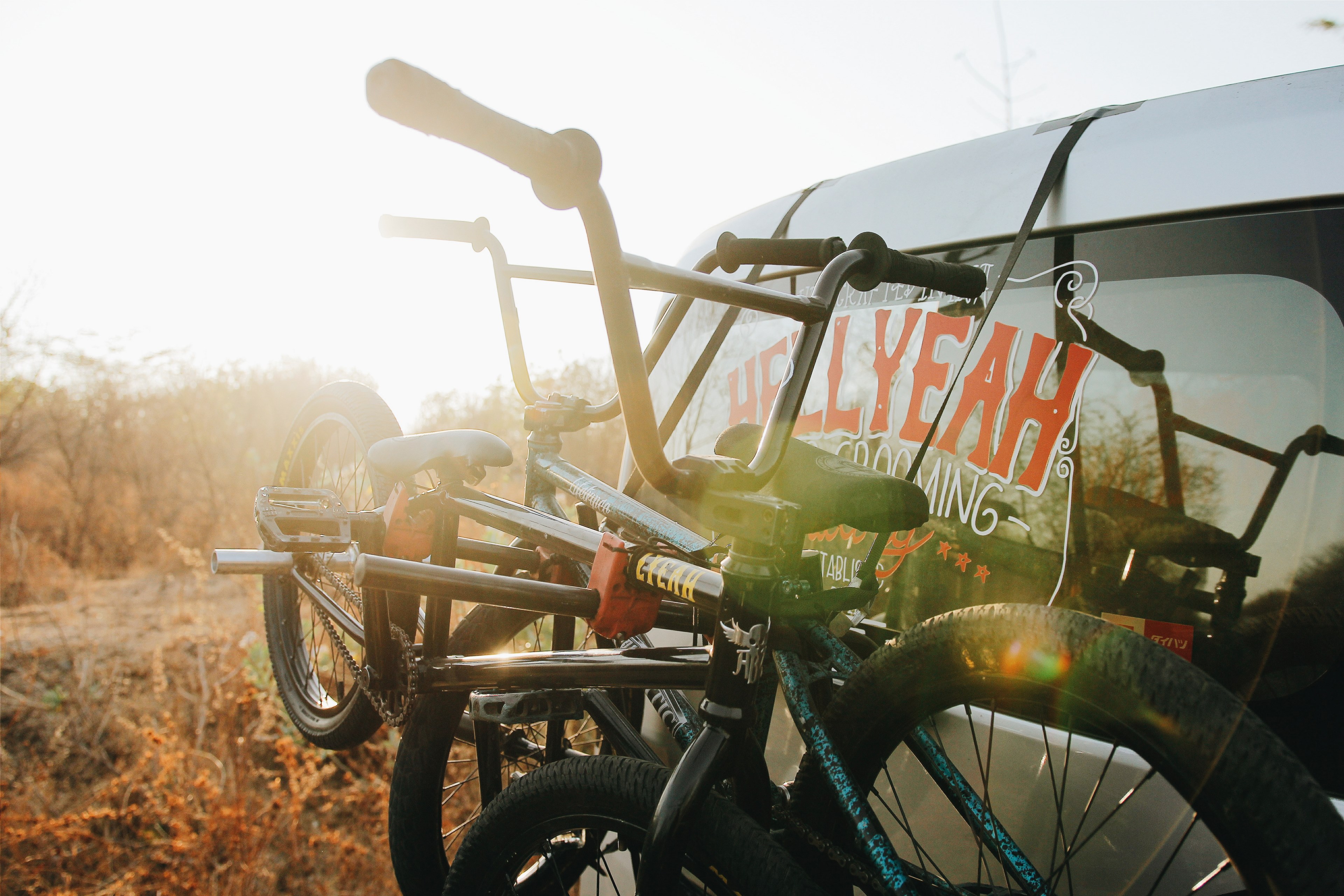 two bicycles attached to a bike rack attached to the back of a car in baluran national park, road trip 4k, HD Wallpaper
