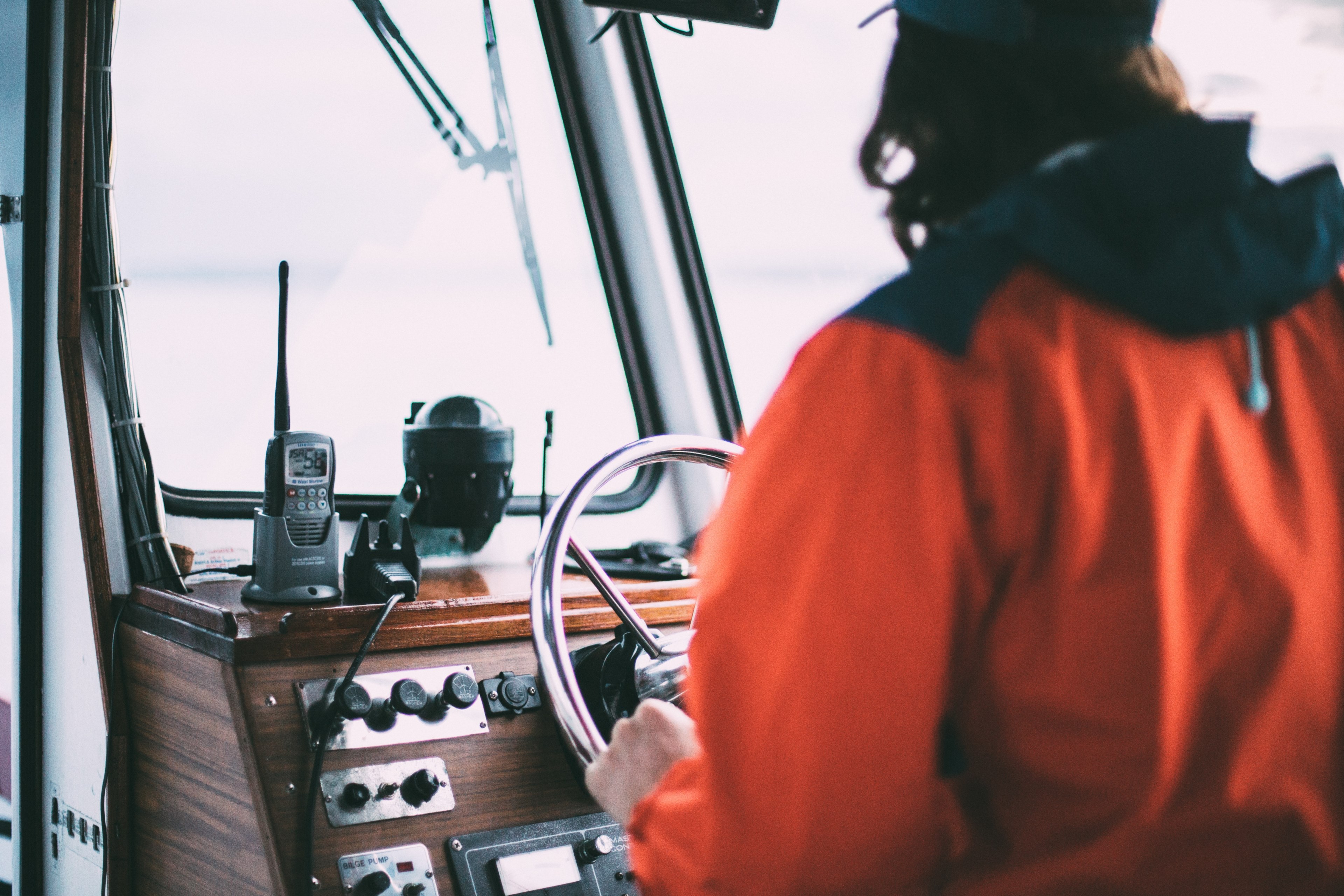 a captain steering the boat as he looks out the into the water, _boat captain 4k, HD Wallpaper