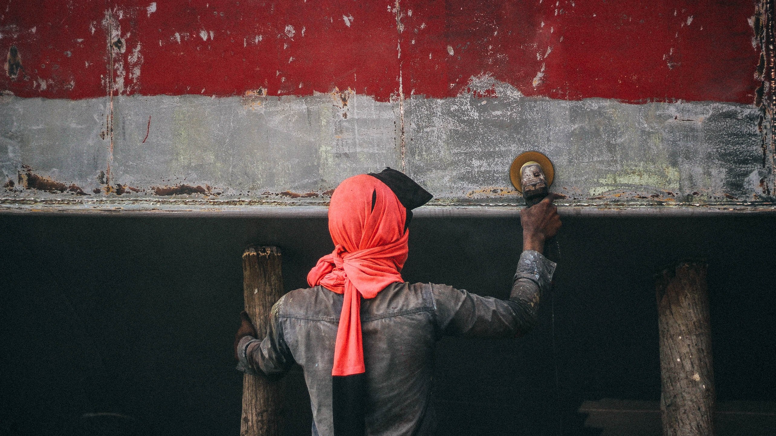 a person wearing a pink headscarf working on restoring a weathered boat, boat restoration 4k, HD Wallpaper