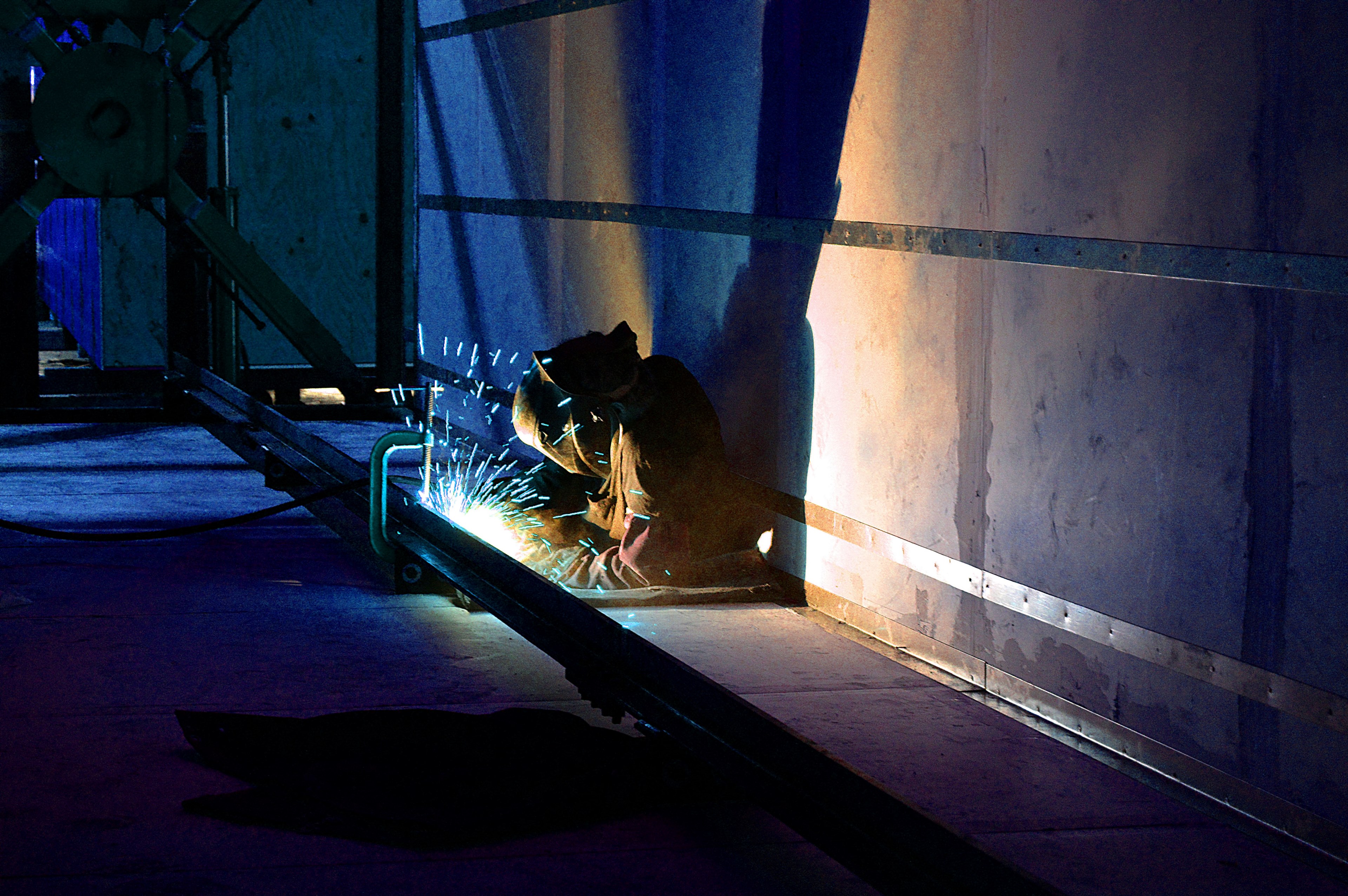 a welder using a welding tool on a piece of metal scaffolding starting light blue sparks, welding in the dark 4k, HD Wallpaper