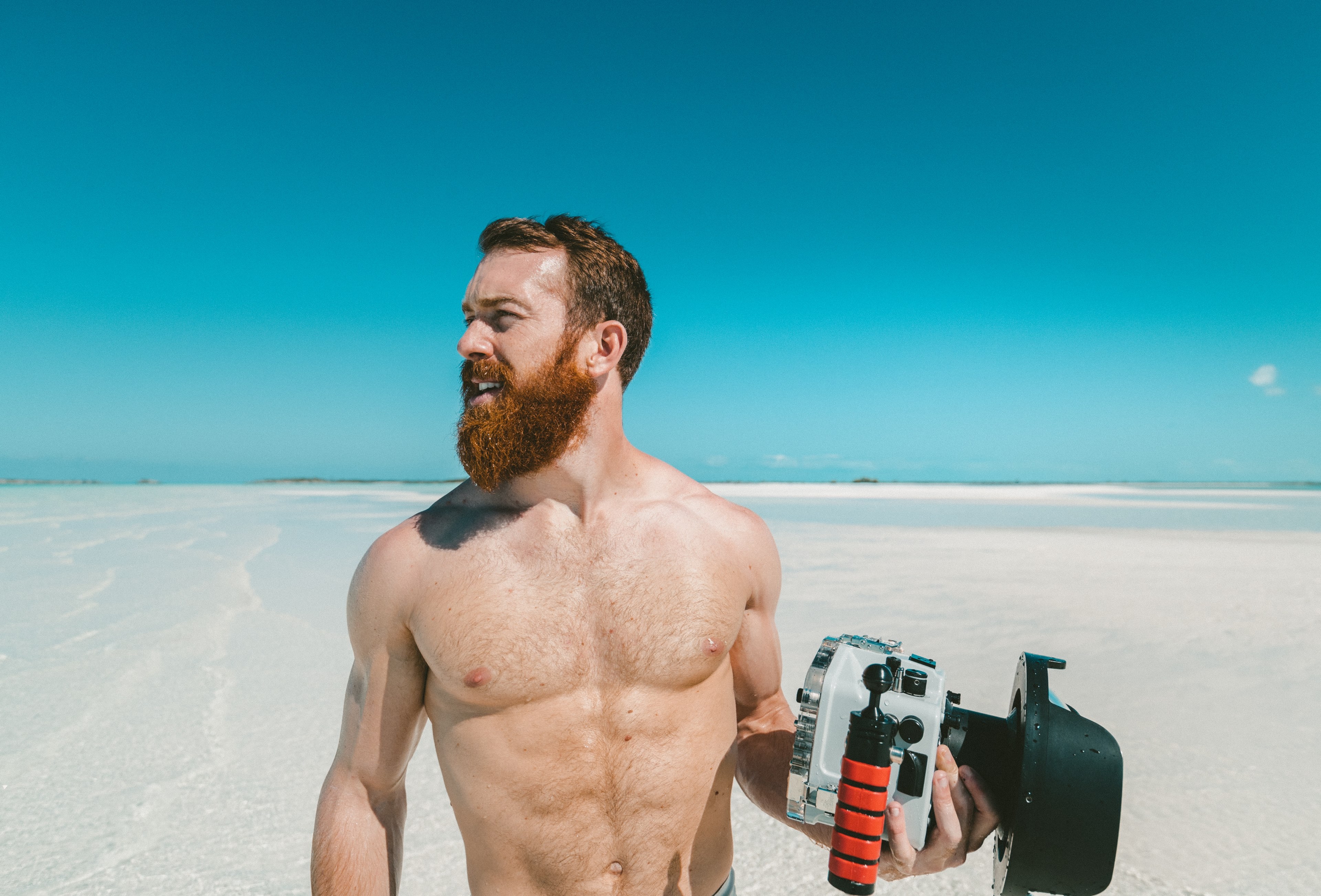 man with a beard holding an underwater camera at the sand beach, man with a camera on a beach 4k, HD Wallpaper
