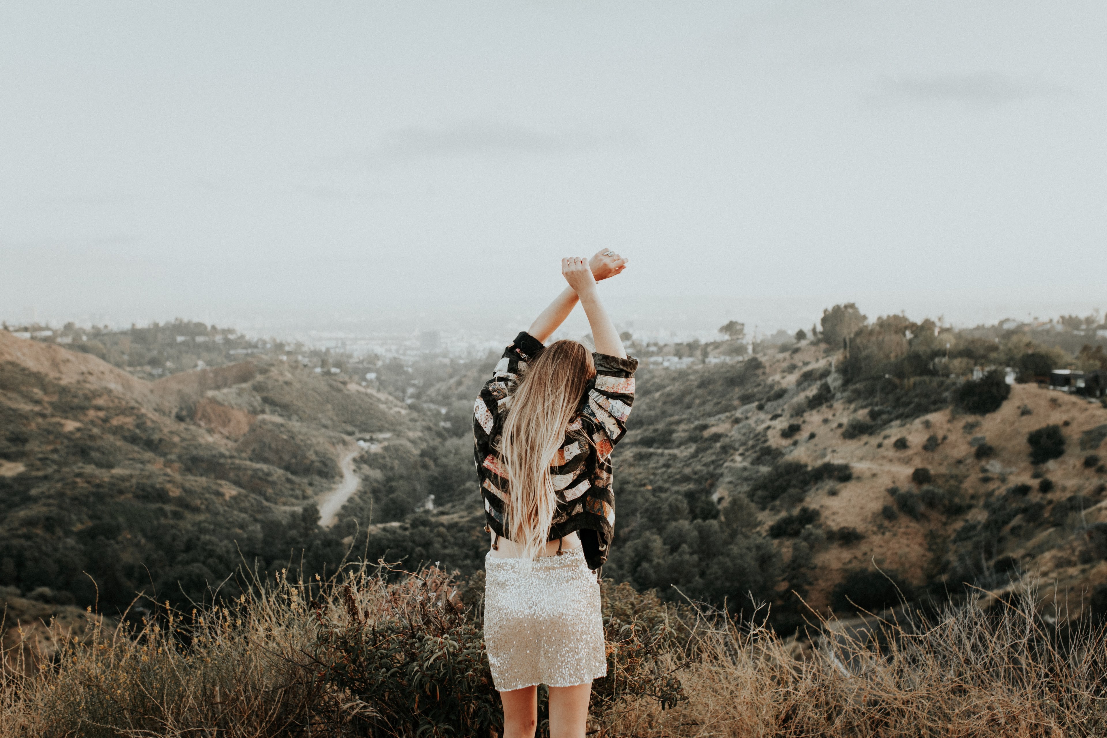 a woman holding her arms up in the sky on top of a mountain, _dancing in la 4k, HD Wallpaper