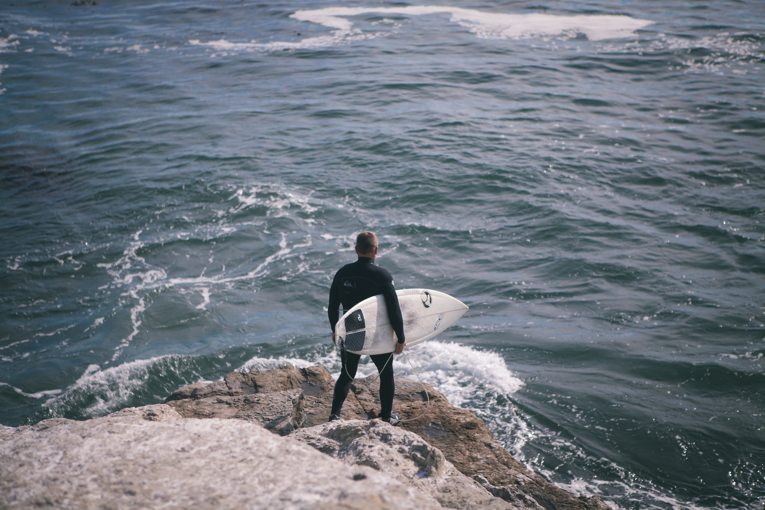 a man holding a surfboard on a rock by the ocean in santa cruz, santa cruz surfer 4k, HD Wallpaper