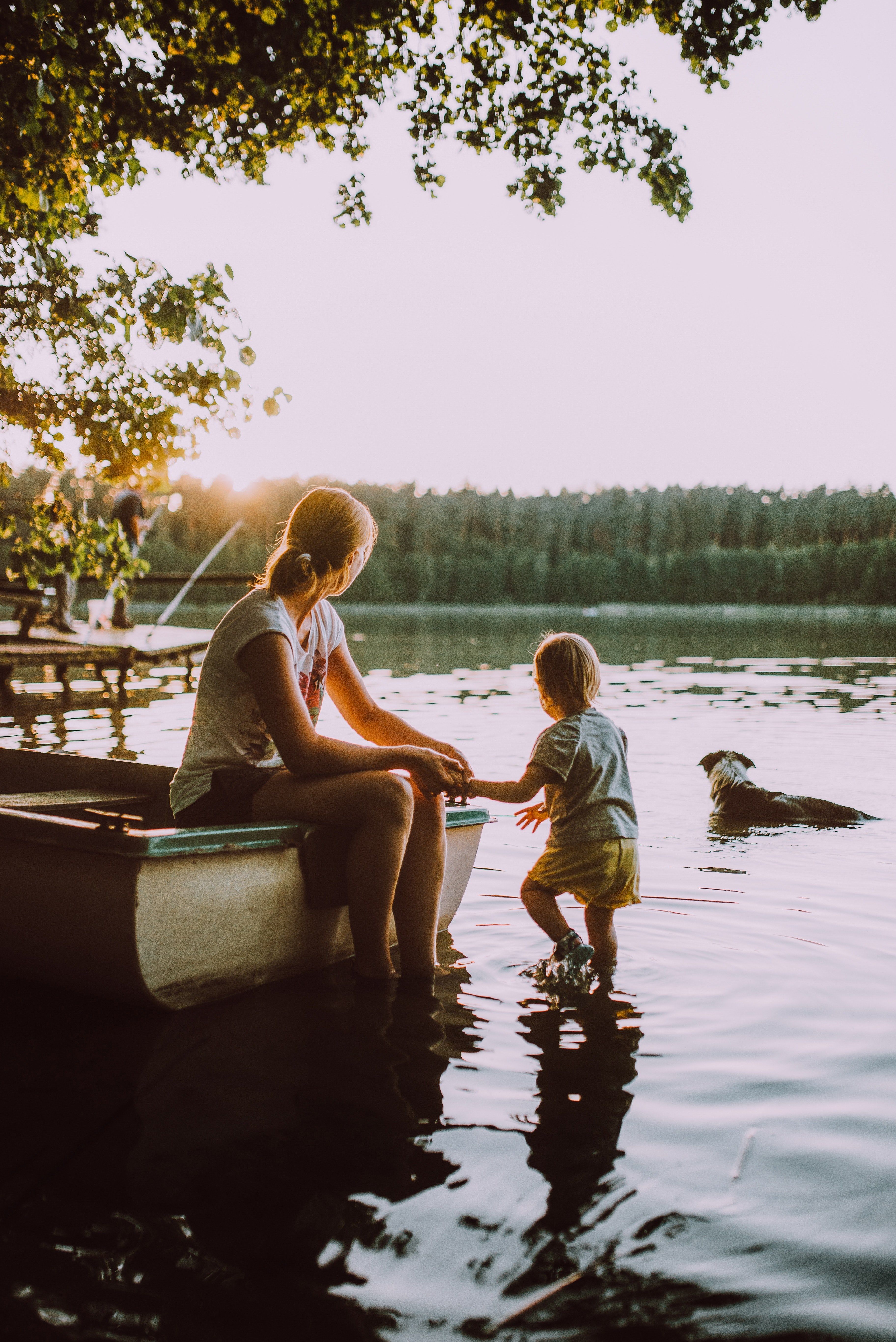 young mother dangles feet into waters edge while child and dog look off into a lake, _calm at waters edge 4k, Phone HD Wallpaper