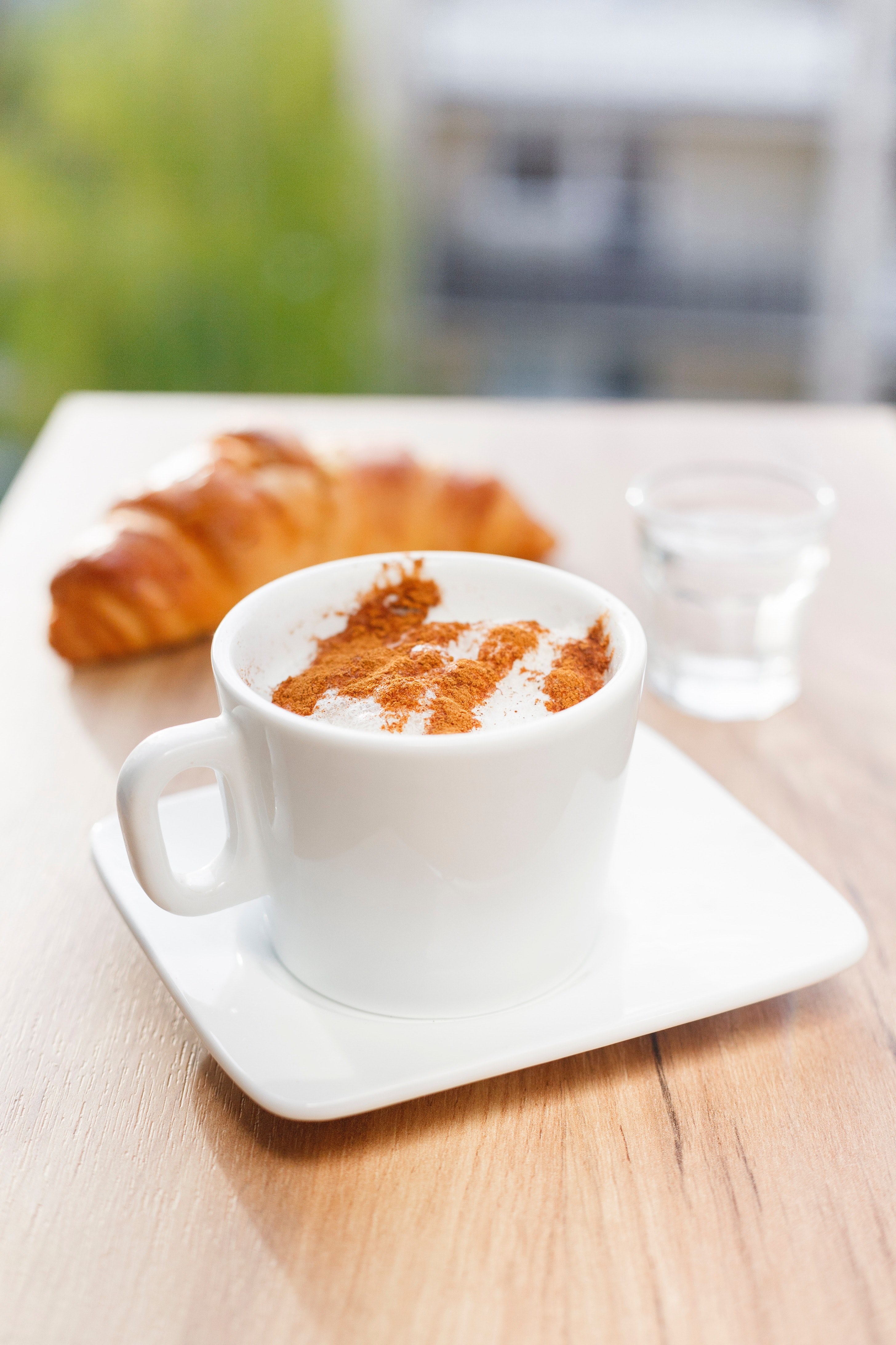 cappuccino in a white mug and saucer with cinnamon on top and a croissant in the background, breakfast on a table 4k, Phone HD Wallpaper