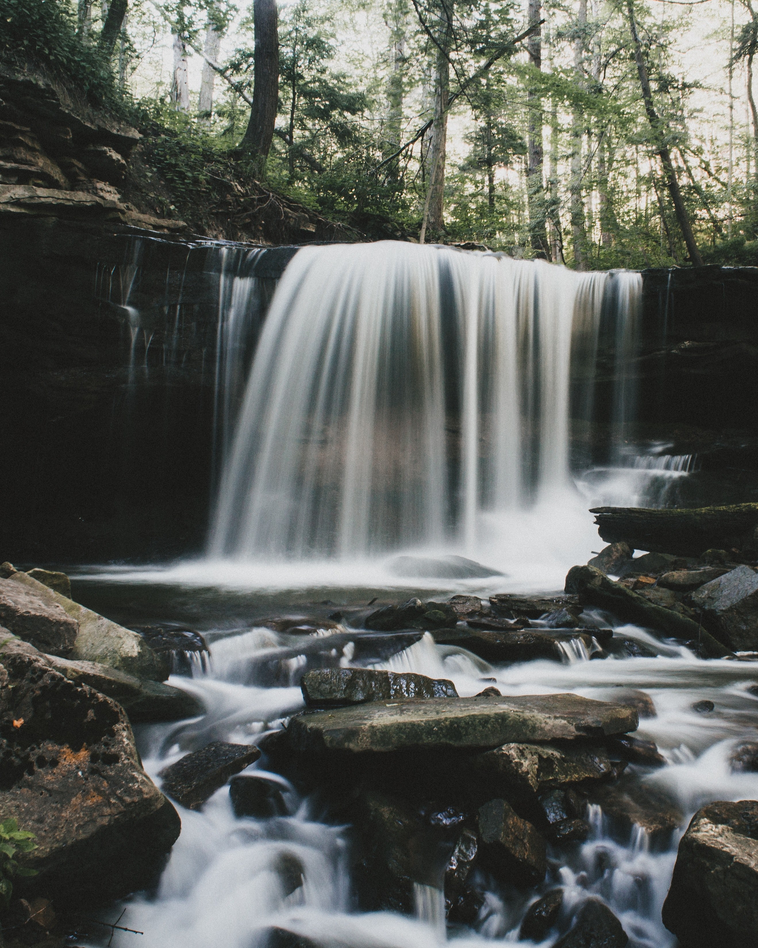 a small waterfall in a forest pouring down on smooth rocks, rocks near a small waterfall 4k, Phone HD Wallpaper