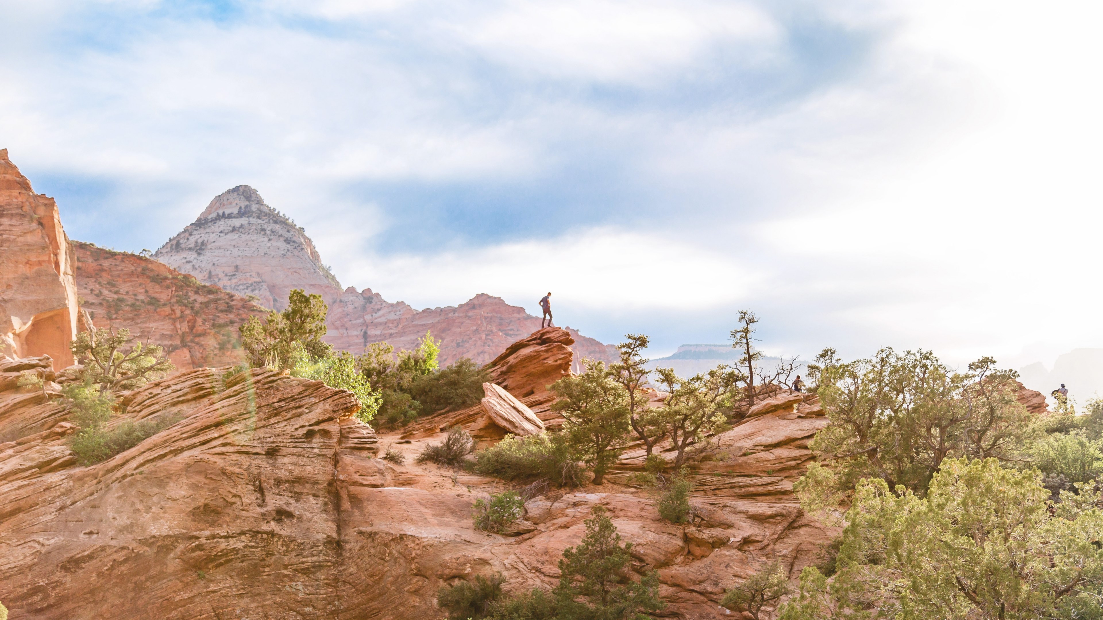 hiker stands on the edge of a rock in the desert landscape, exploring from above 4k, HD Wallpaper
