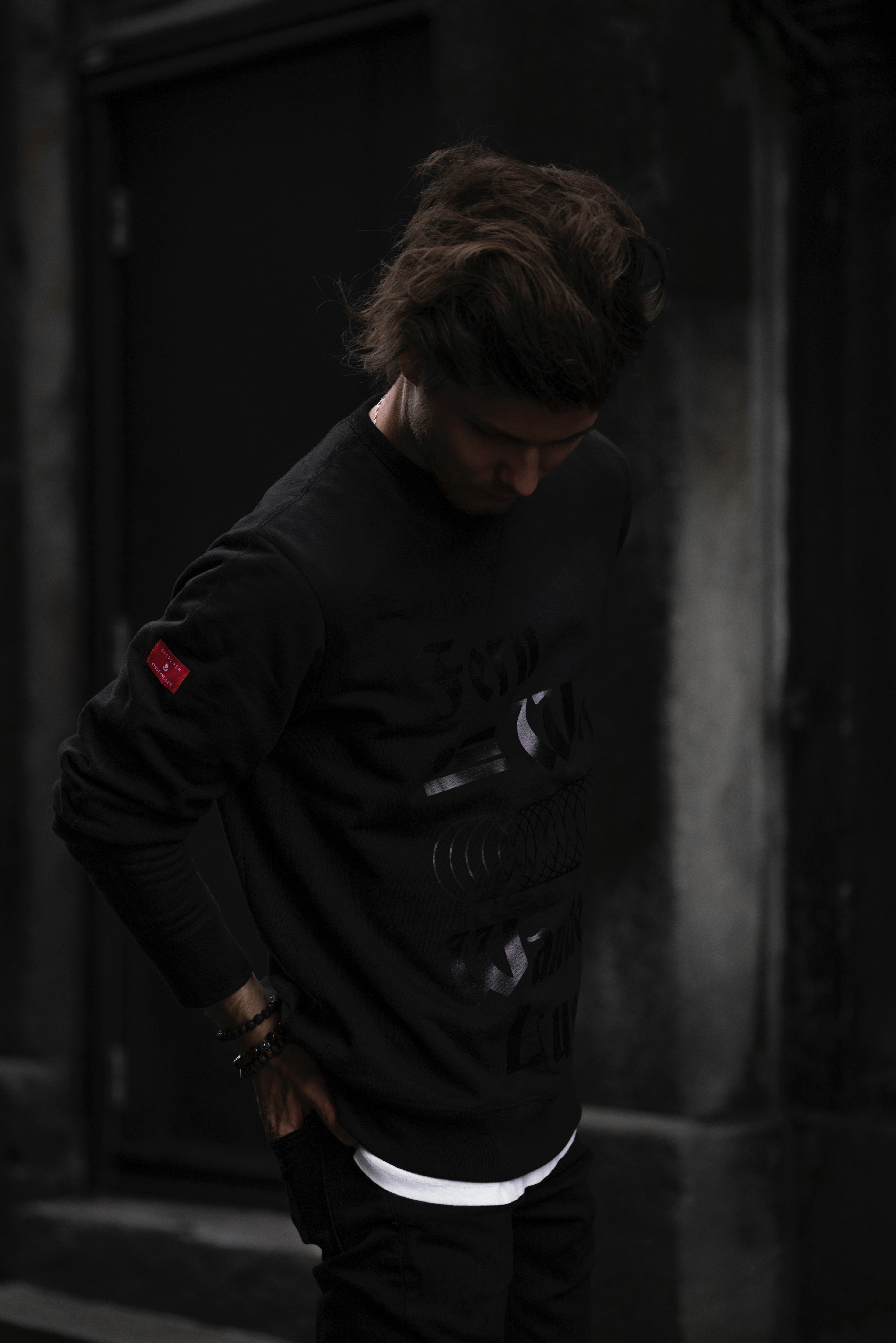 a person in silhouette poses in dark clothing against a dim background, the urban explorer sweatshirt 4k, Phone HD Wallpaper