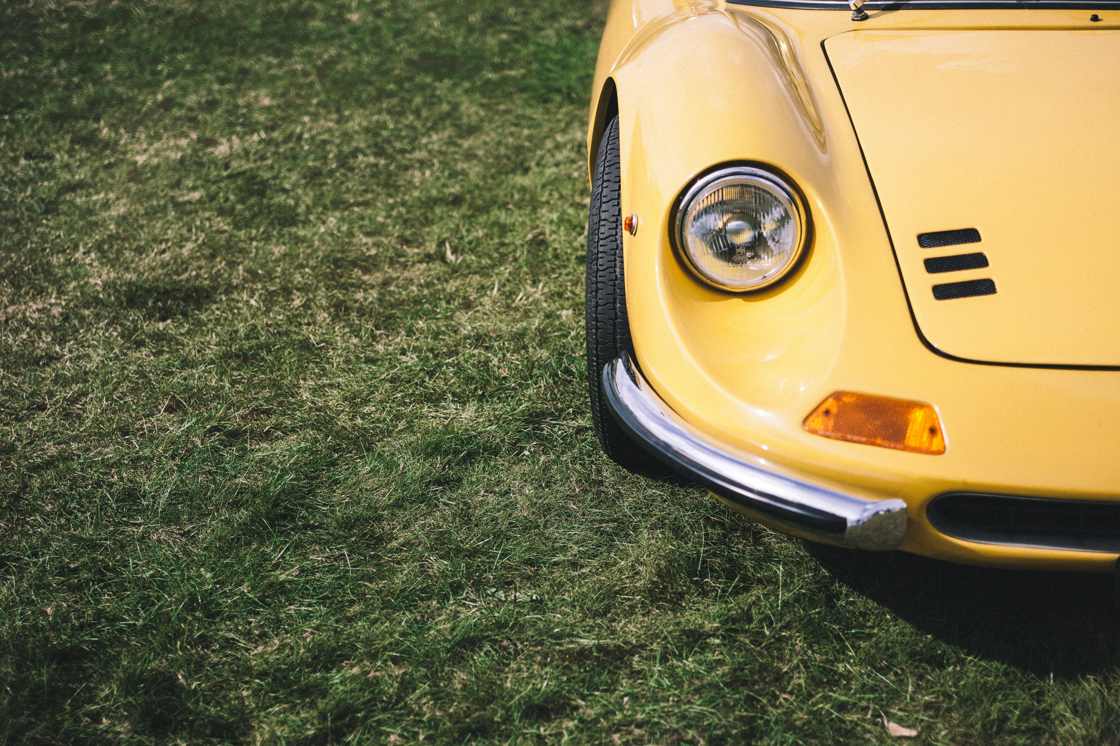 a shot of the front of a classic yellow car parked next to the grass, _yellow porsha 4k, HD Wallpaper