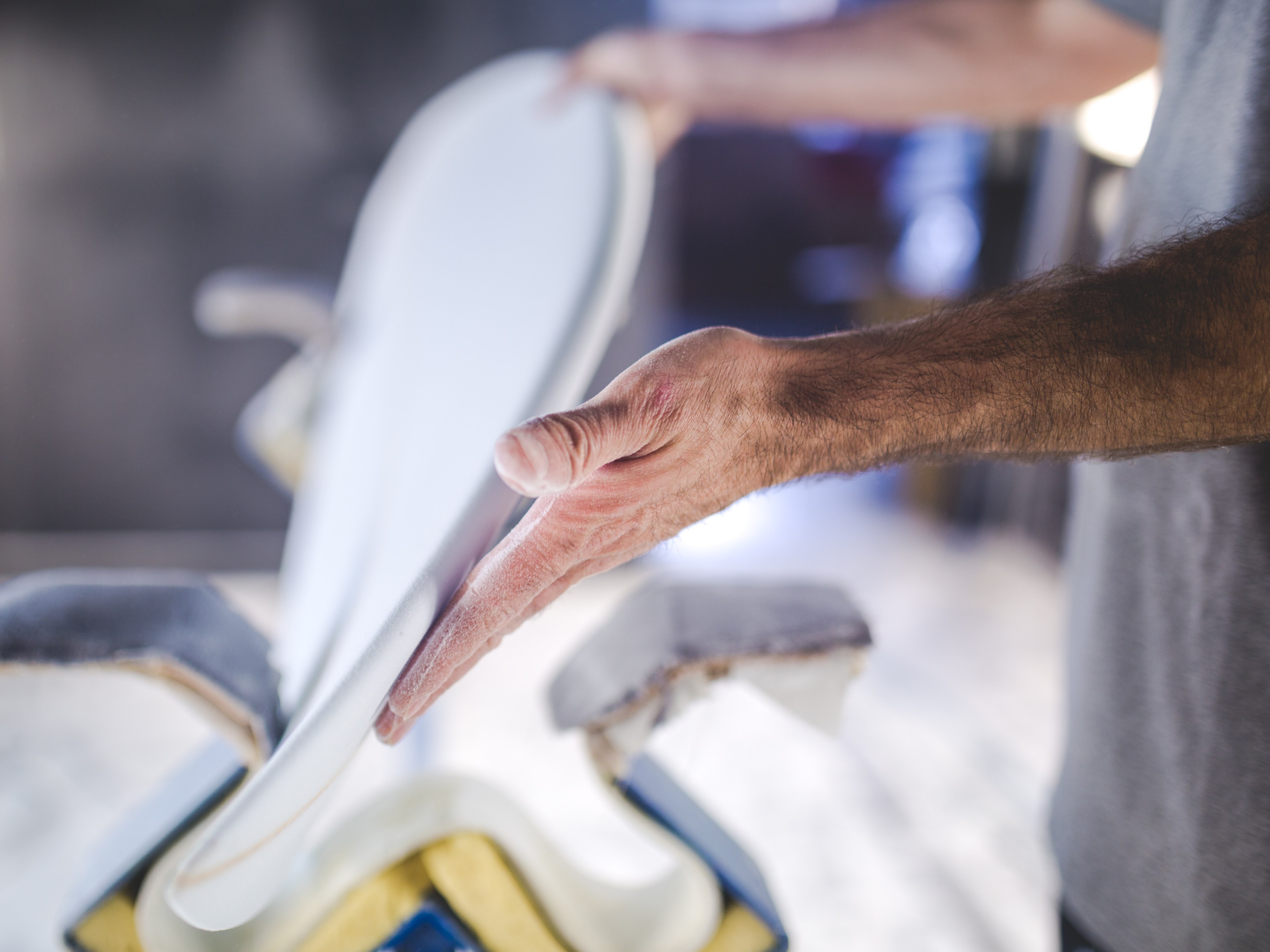 a blurry shot of a mans hands holding a handmade part of a surfboard, handmade surfboard 4k, HD Wallpaper