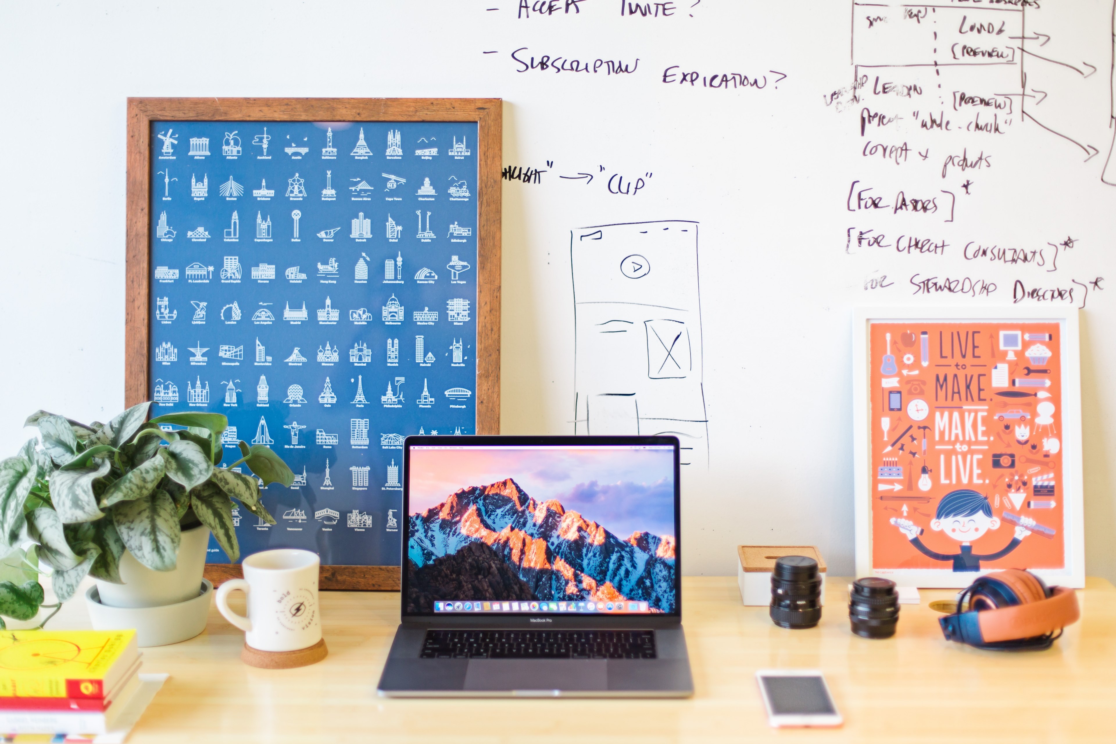 a workspace with a macbook two posters and drawings on the white wall, designers desk 4k, HD Wallpaper