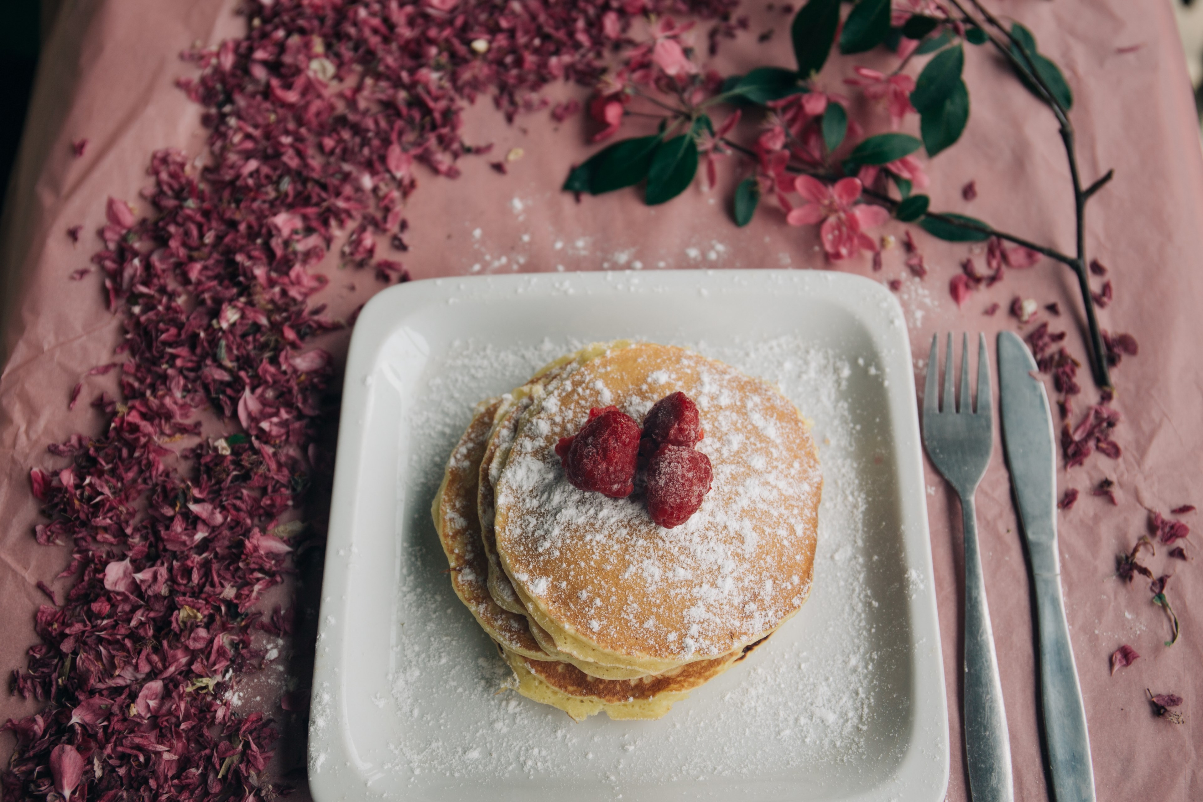 delicious looking pancakes covered in berries and powdered sugar on a plate that is sitting on a table with flowers on it, millennial pink pancakes 4k, HD Wallpaper