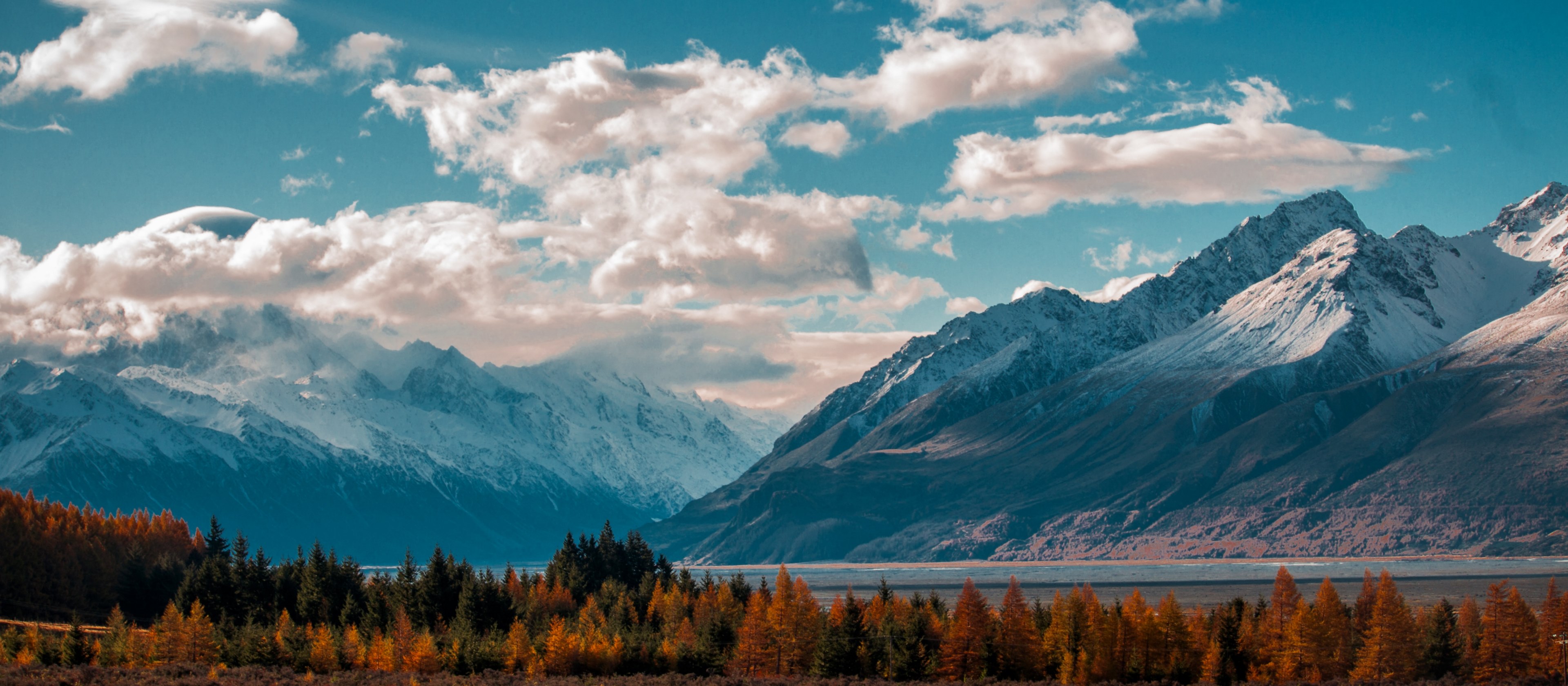 the fluffy clouds surrounding the snowcapped mountains near lake pukaki and the forest, autumn trees by a lake 4k, HD Wallpaper