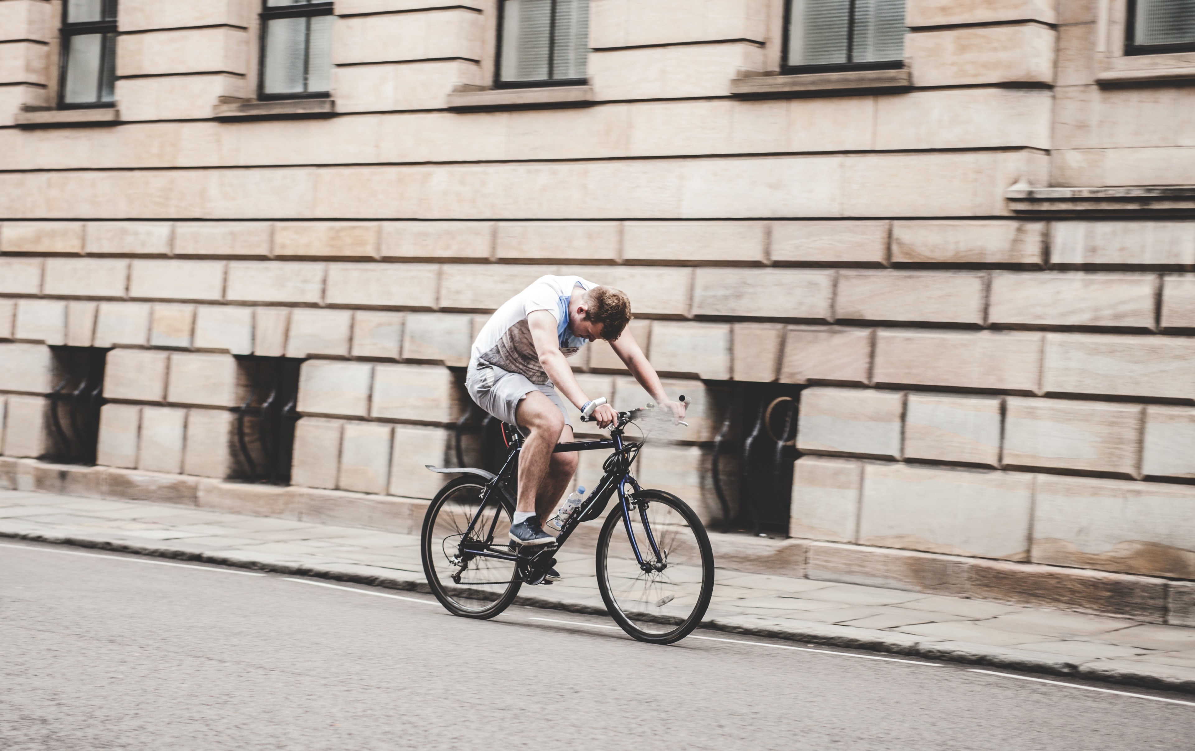 a man rides a bicycle next to the curb on a street in cambridge looking down, man riding bicycle 4k, HD Wallpaper