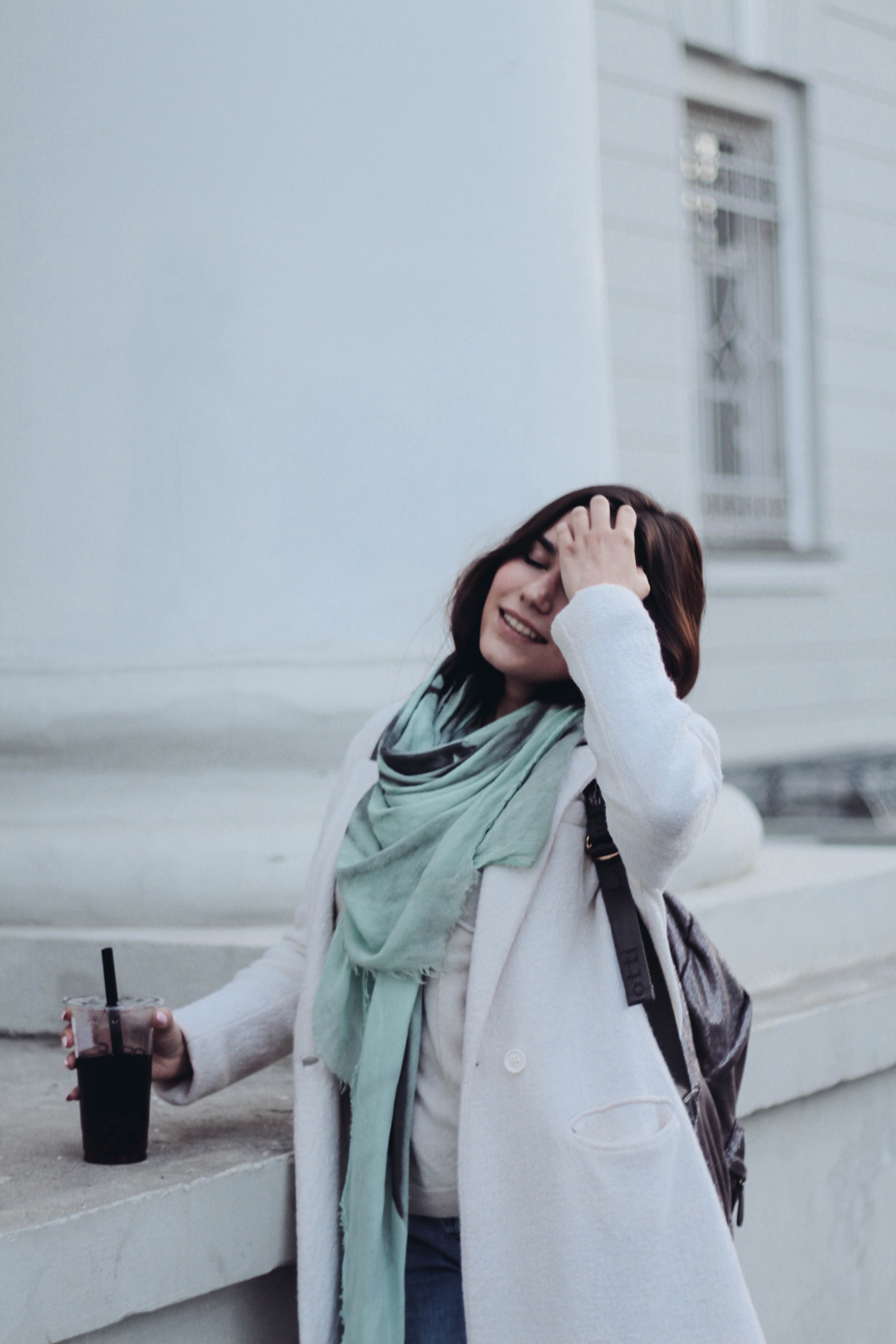 a woman with a drink with a straw in her hand standing by a ledge and smiling, smiling woman with a drink 4k, Phone HD Wallpaper