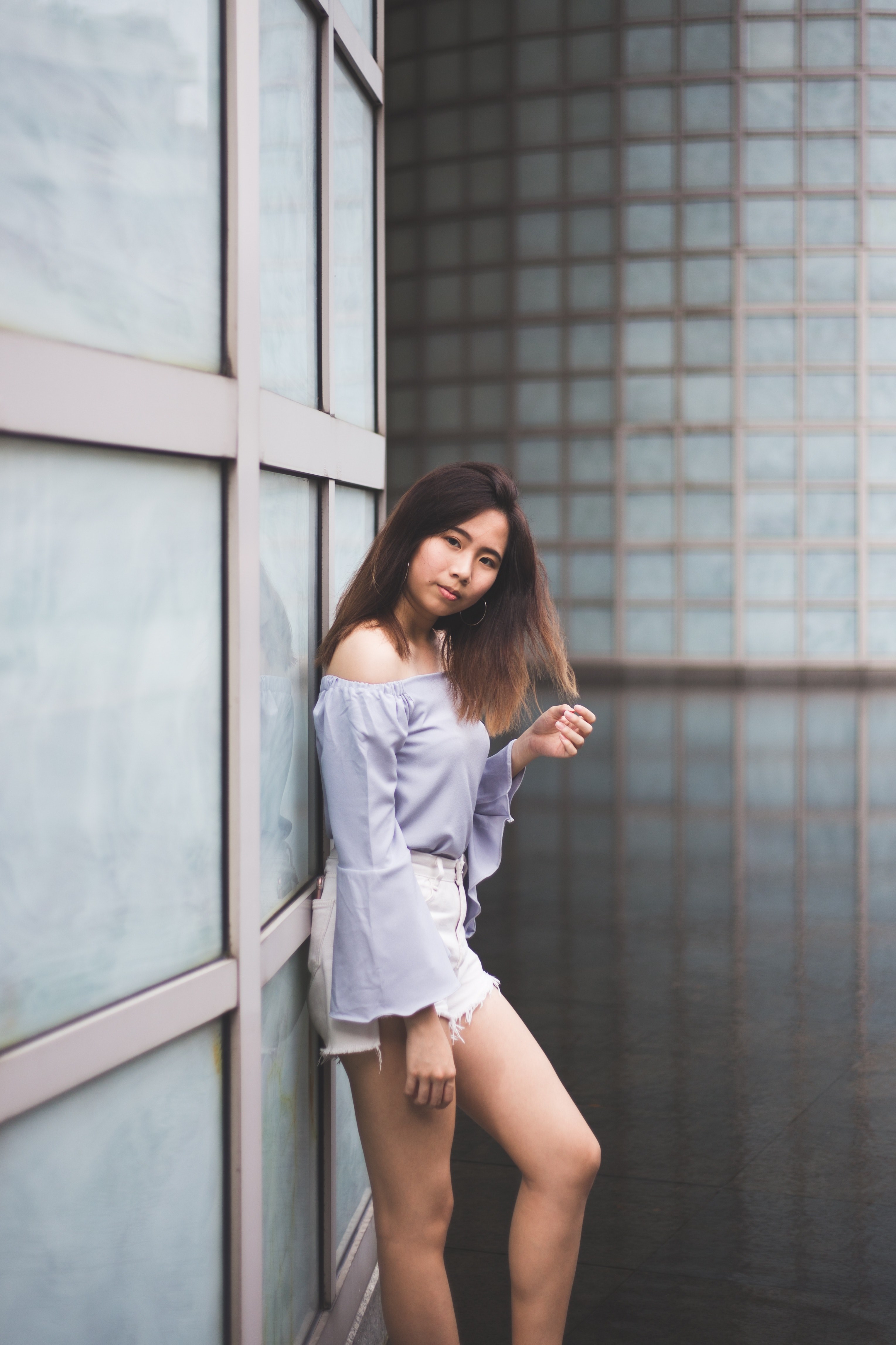 a woman in an off the shoulder top leans against windows in a building in singapore, woman leaning against windows 4k, Phone HD Wallpaper