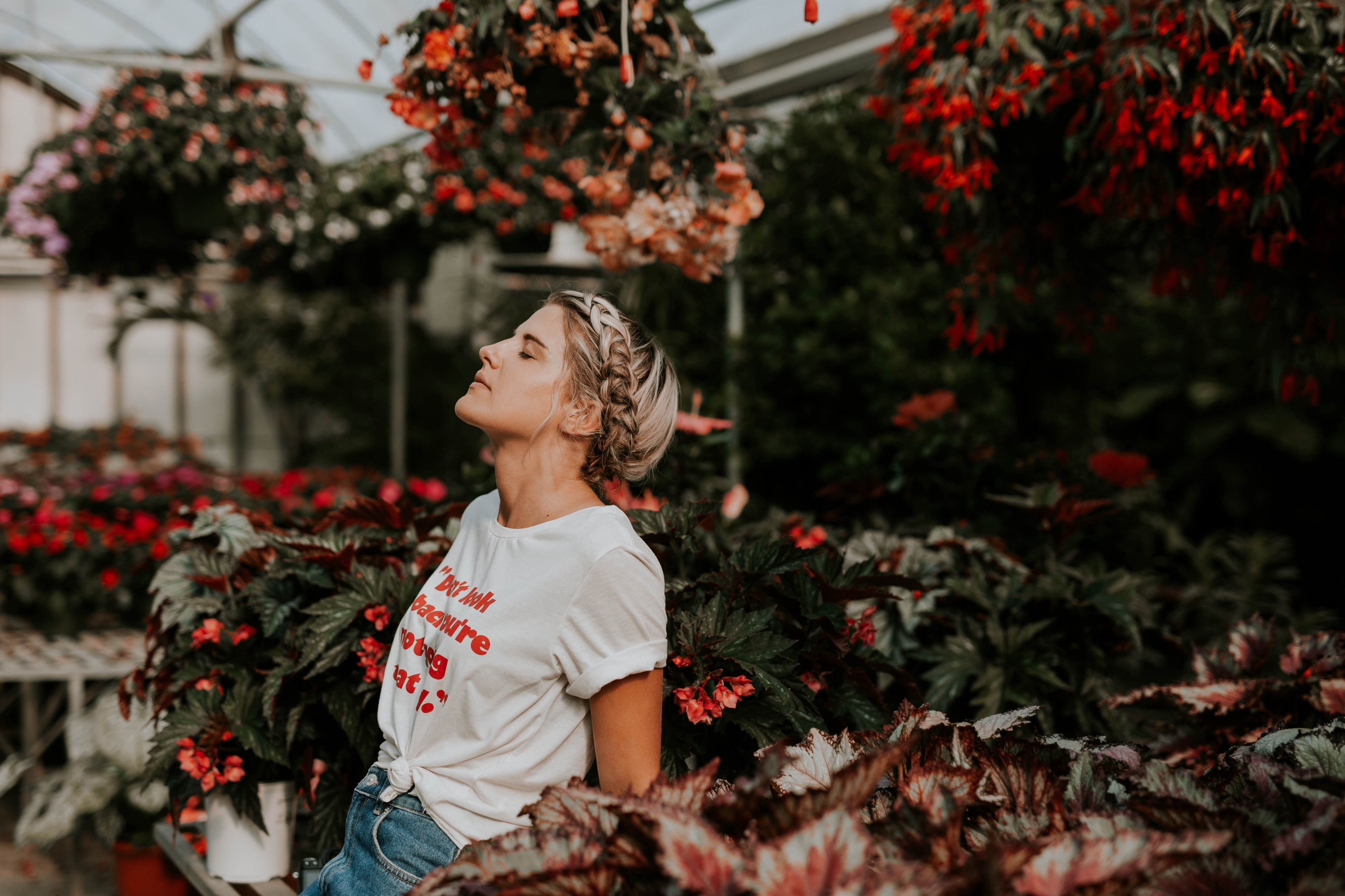 a woman with a braid closes her eyes with her head back in a botanical garden, woman in botanical garden 4k, HD Wallpaper