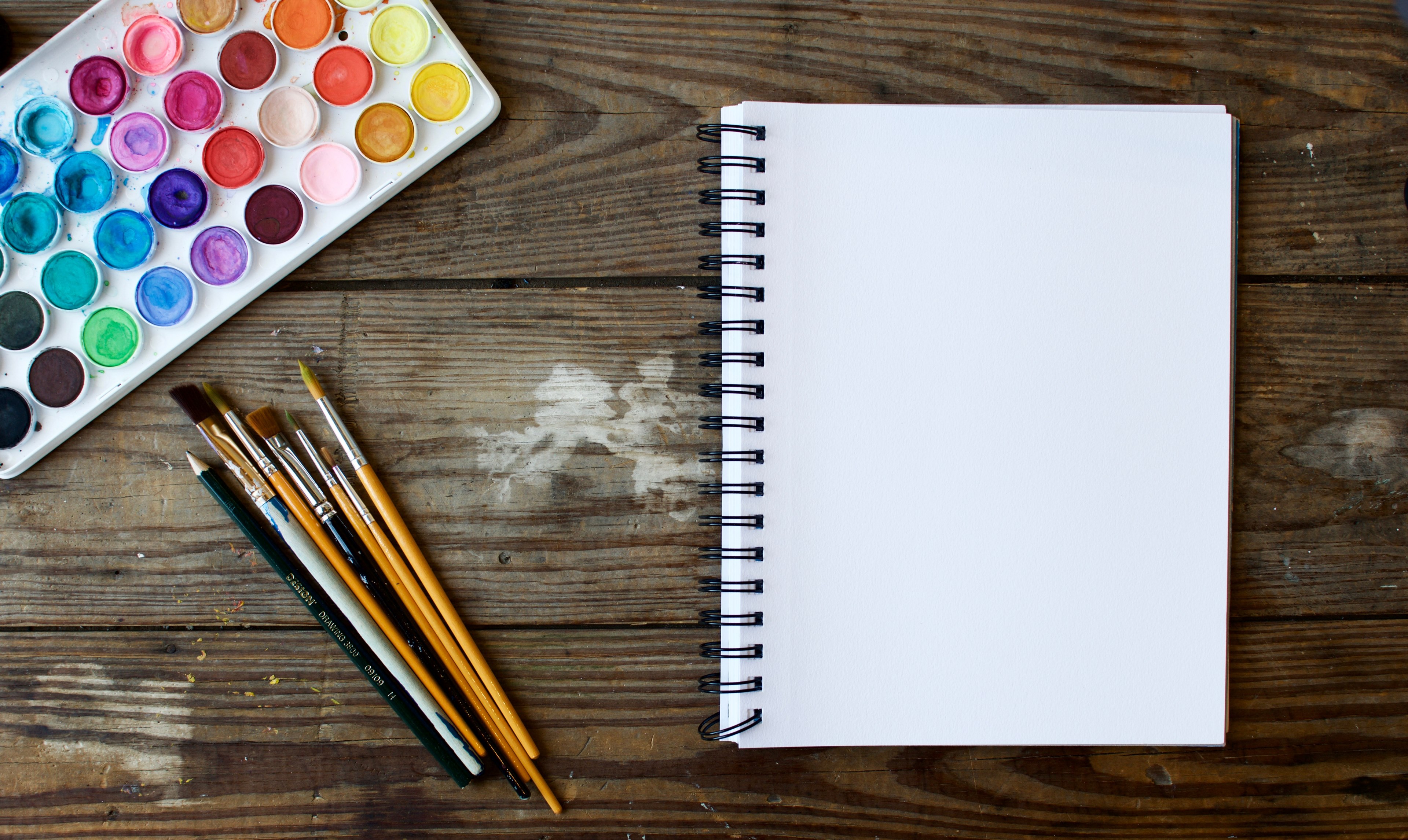 a set of paintbrushes and a watercolor palette laid out next to a blank notebook on a worn out wooden surface, when inspiration strikes 4k, HD Wallpaper