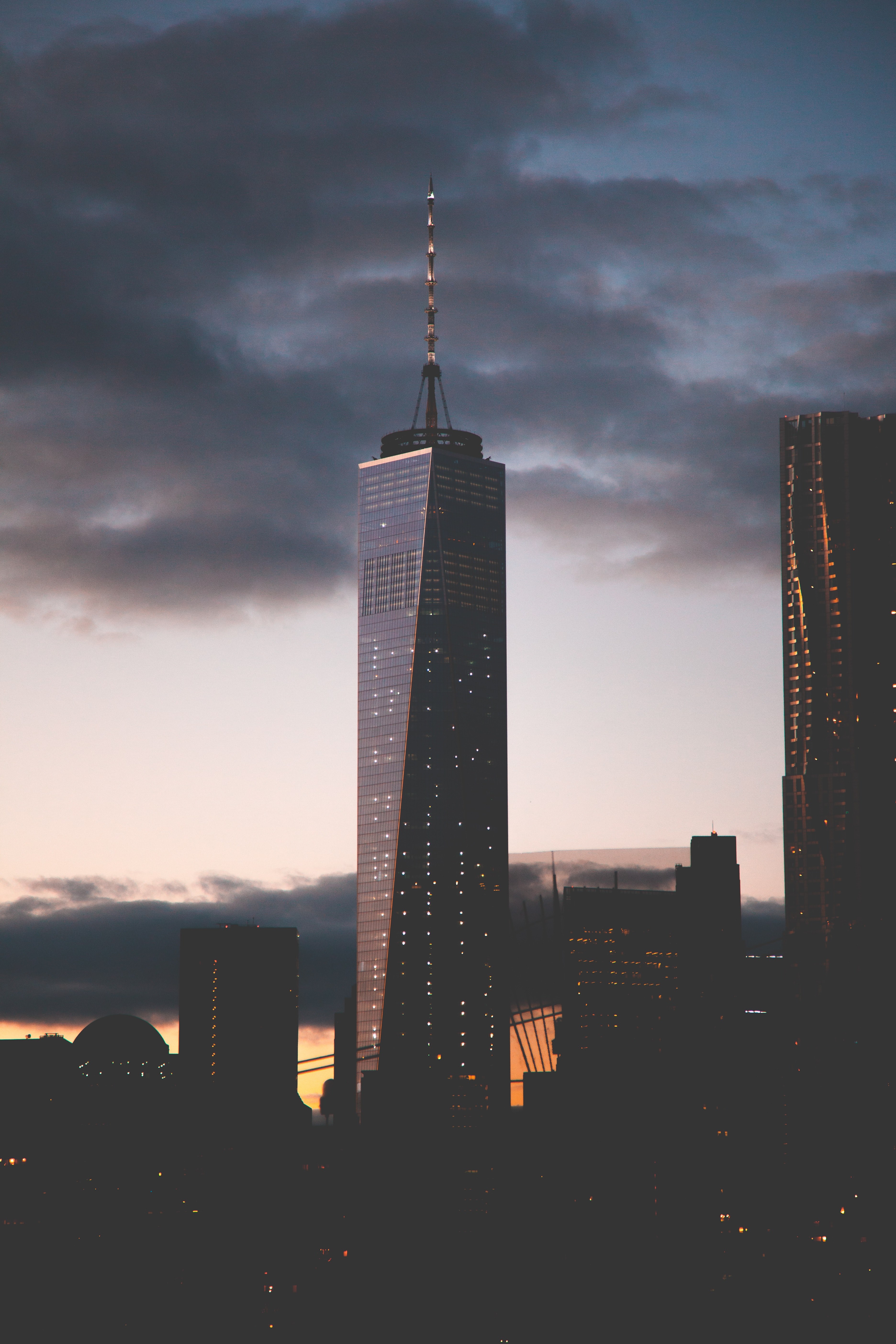 a dim shot of a skyscraper with a long spire in new york on an evening, new york cityscape 4k, Phone HD Wallpaper