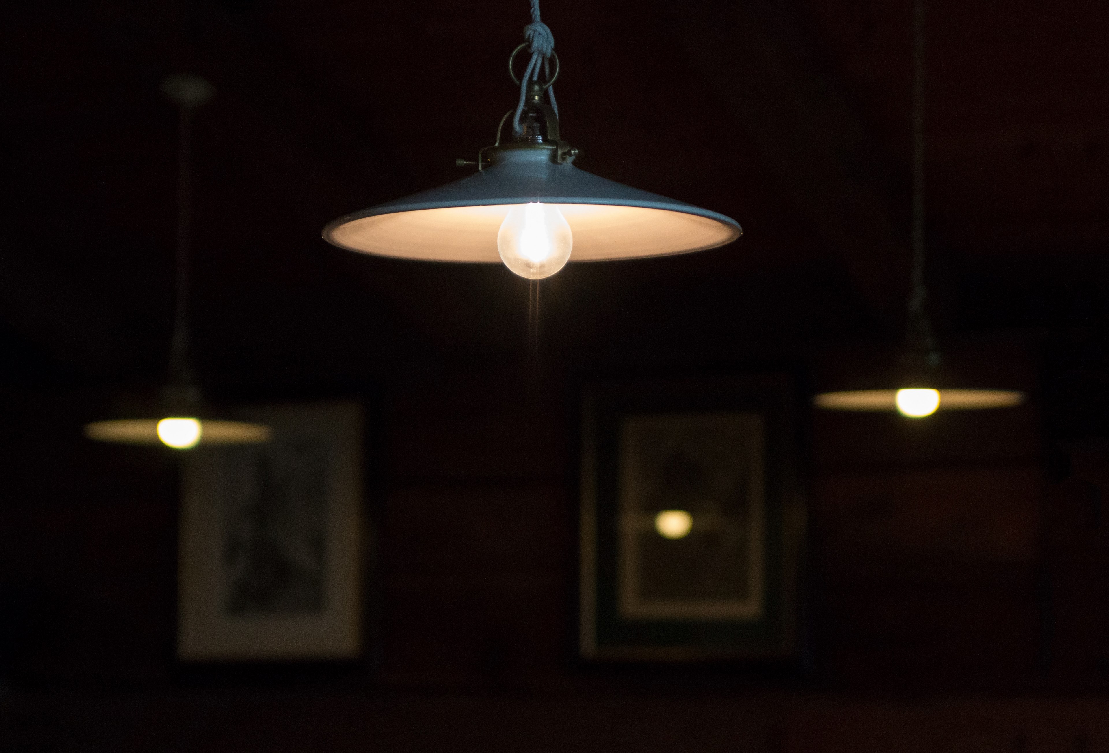 industrial lamps hang from a ceiling in a living room, warm light in the dining room 4k, HD Wallpaper