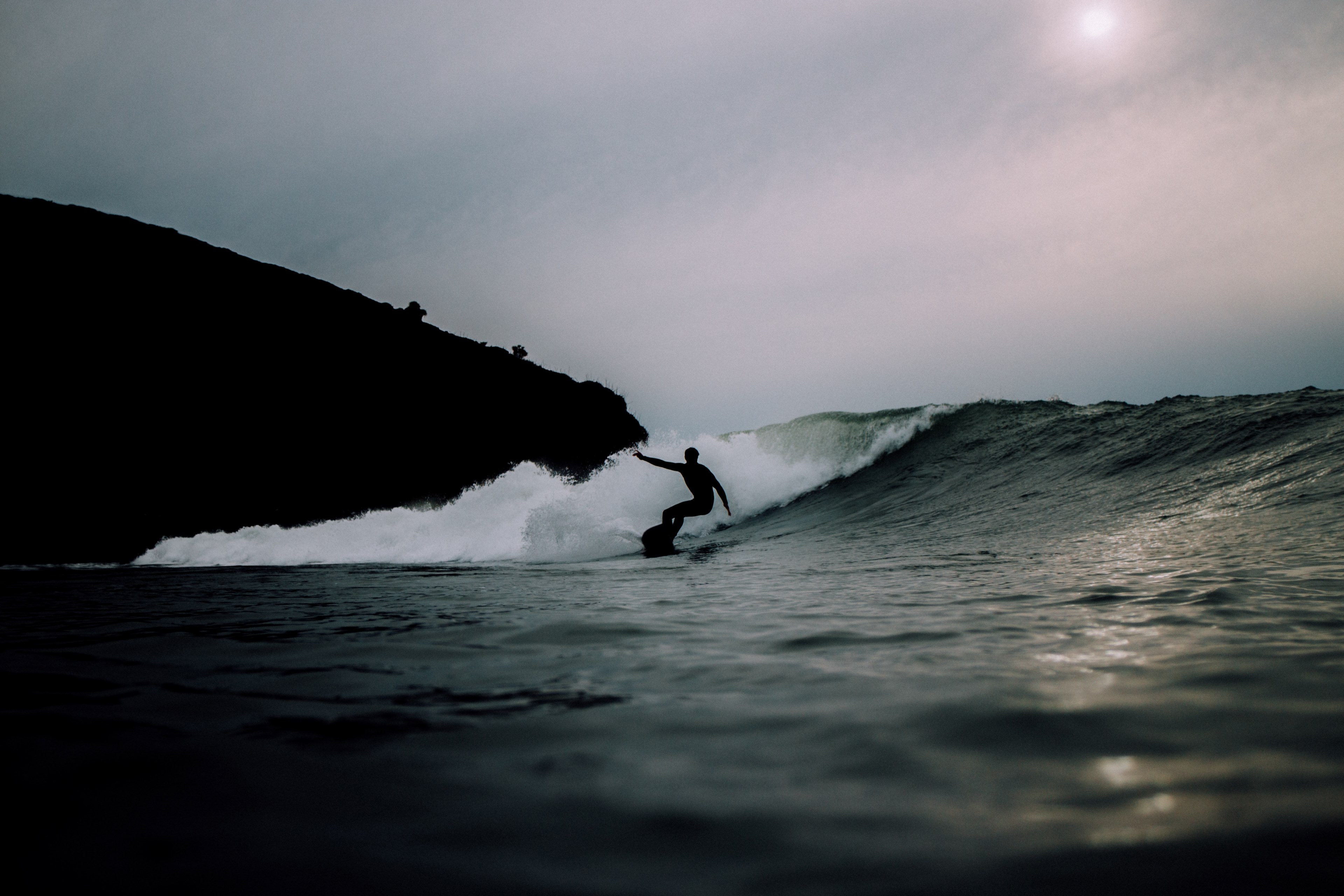 a person wearing a wetsuit surfing a wave in whale bay, surfing the sea at dusk 4k, HD Wallpaper