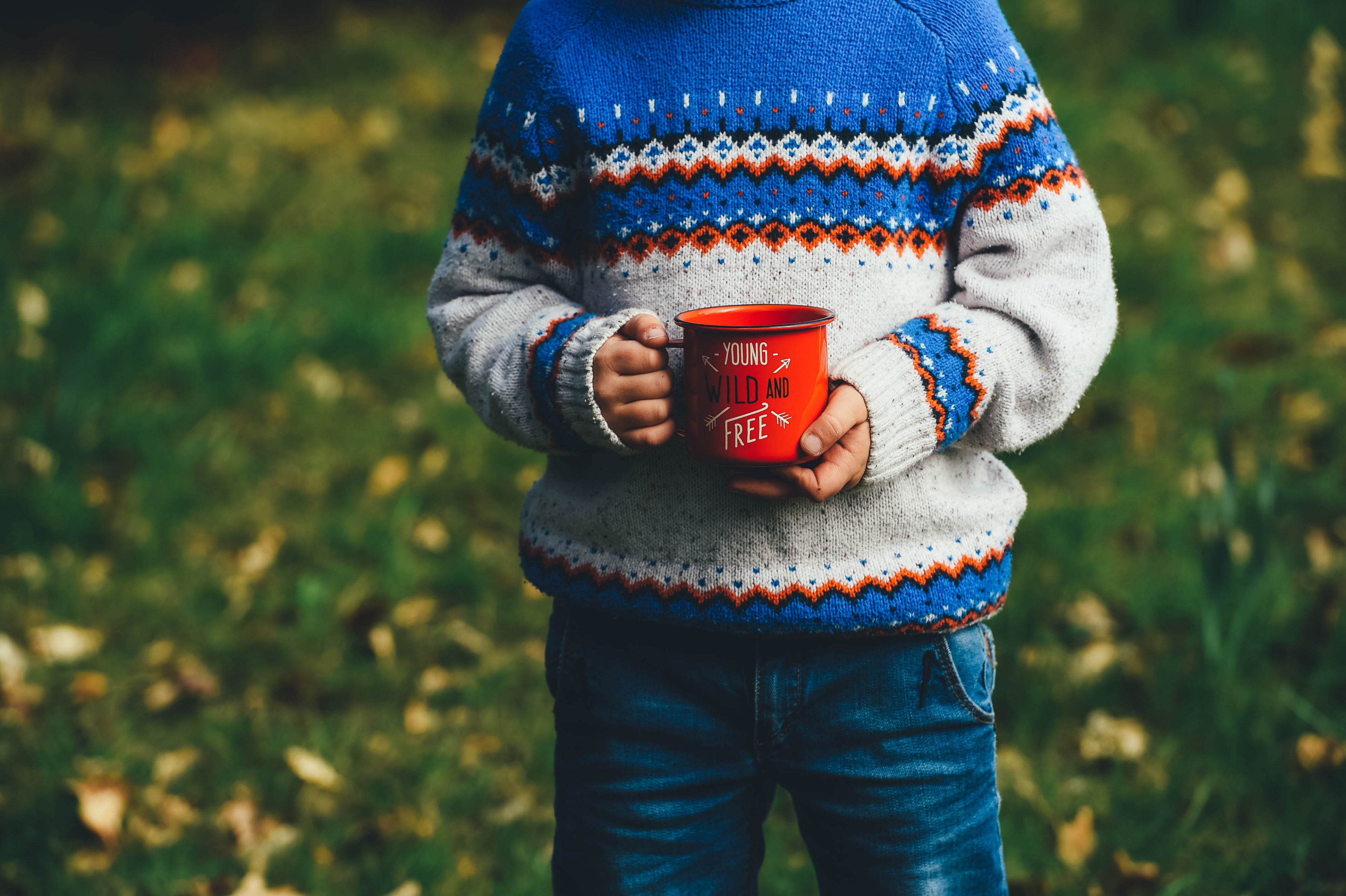 a child holding a red enamel cup with young wild and free written on it, child with a red cup 4k, HD Wallpaper
