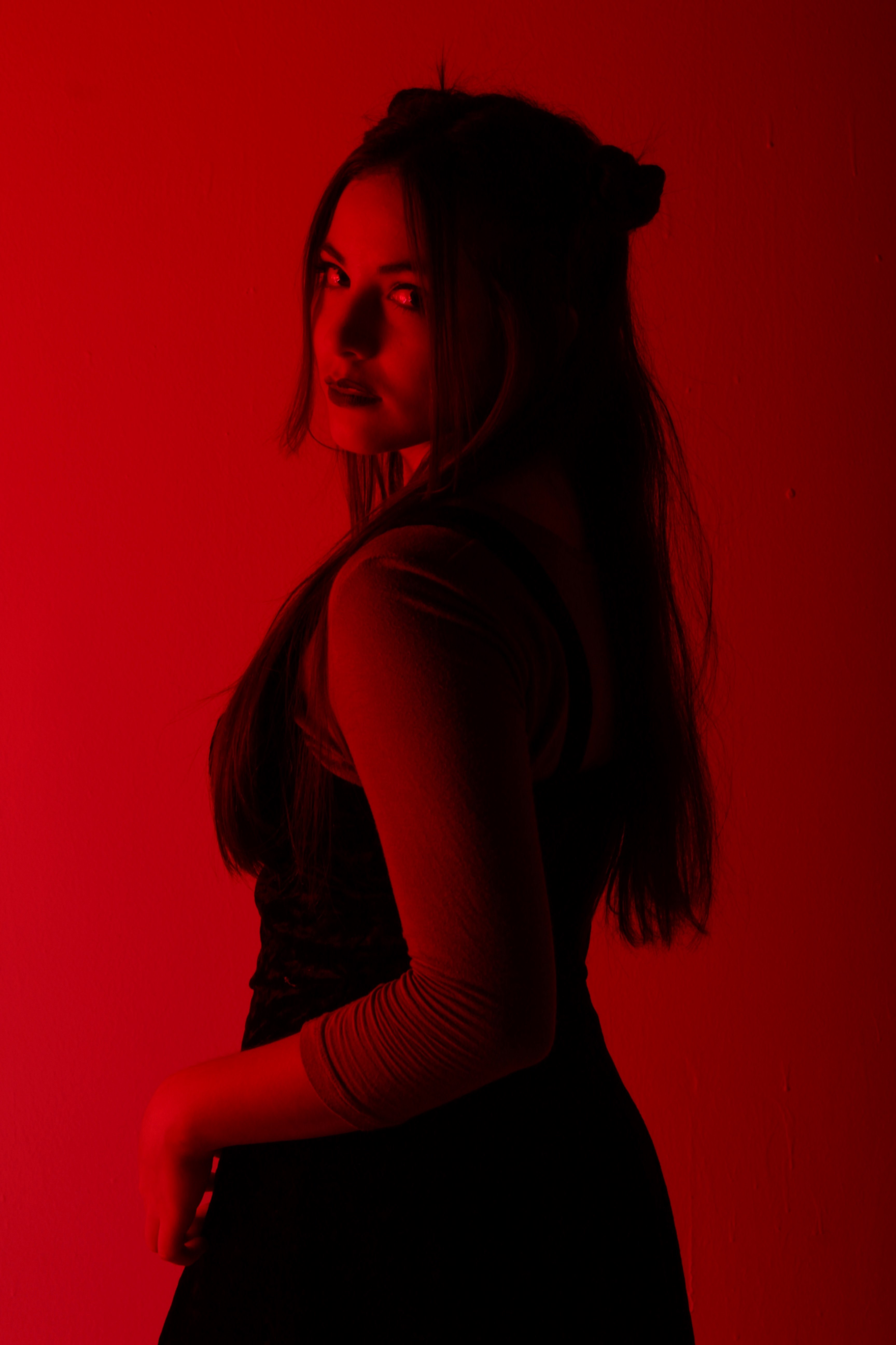 a long haired model cast in red light looks over her shoulder at the camera, rojo_ 4k, Phone HD Wallpaper
