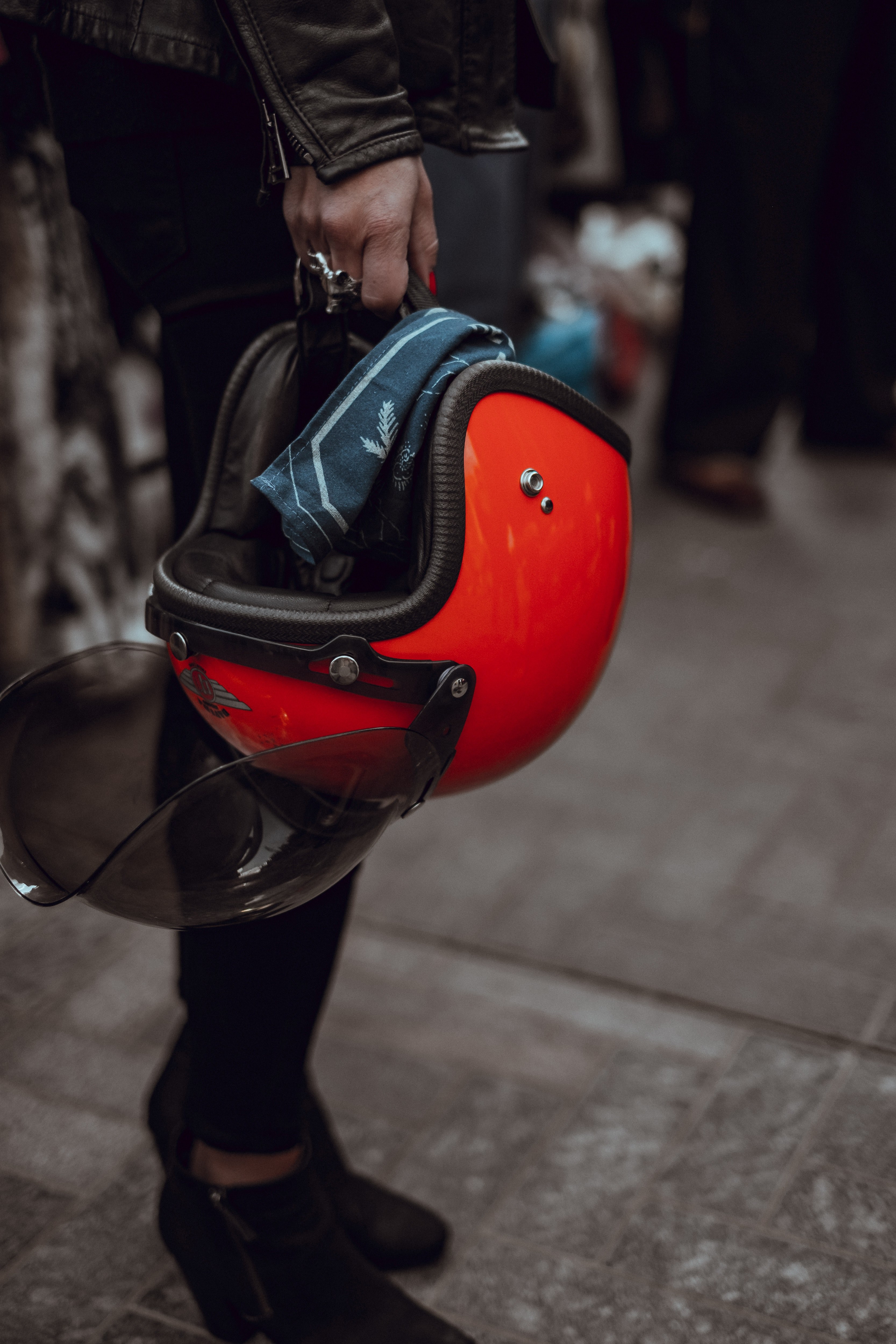 a person wearing a leather jacket carrying a red helmet, red helmet 4k, Phone HD Wallpaper