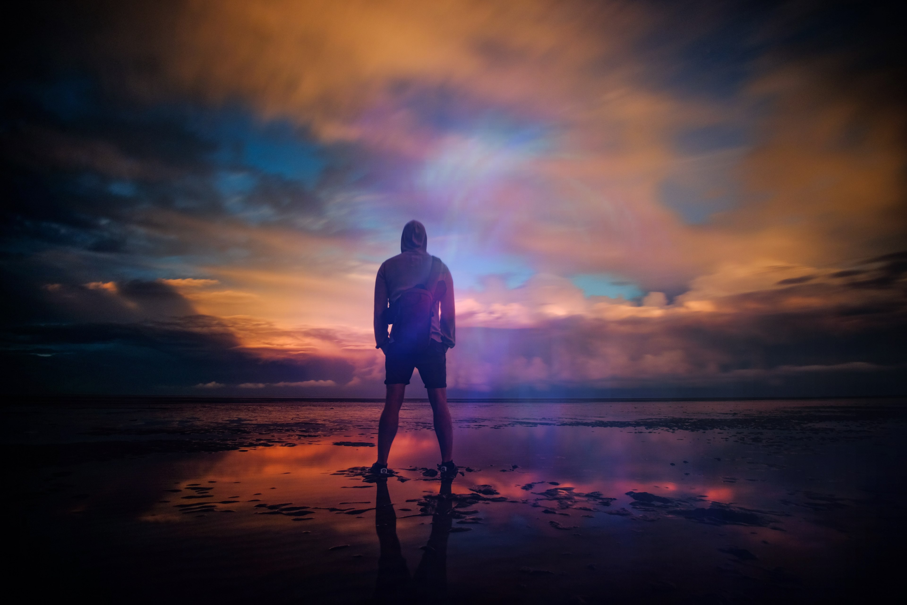 a man standing triumphant on a beach in new romney while looking out into the water, endless 4k, HD Wallpaper