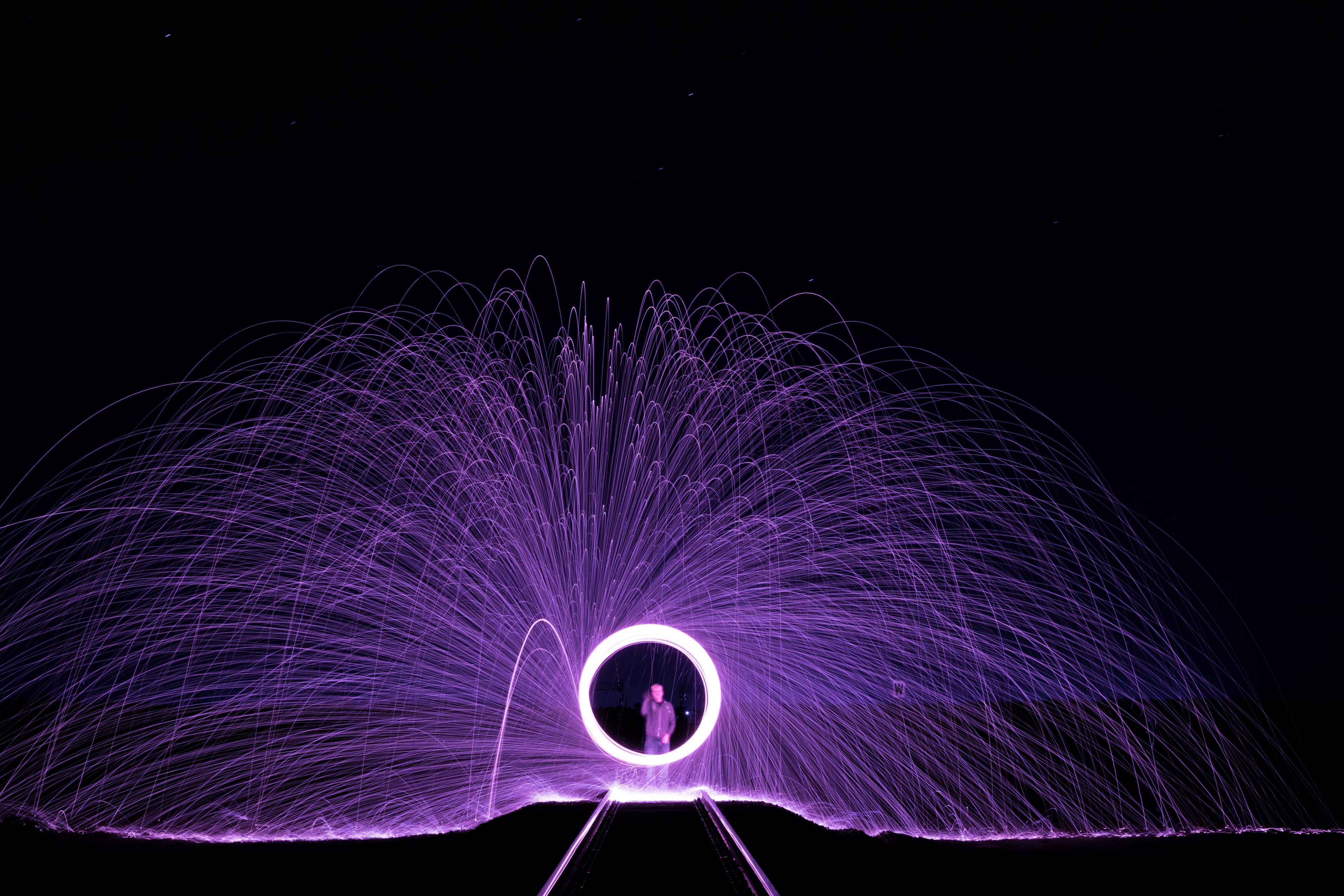 a long exposure shot of purple light painting circles on a train track in laton, electric rain 4k, HD Wallpaper
