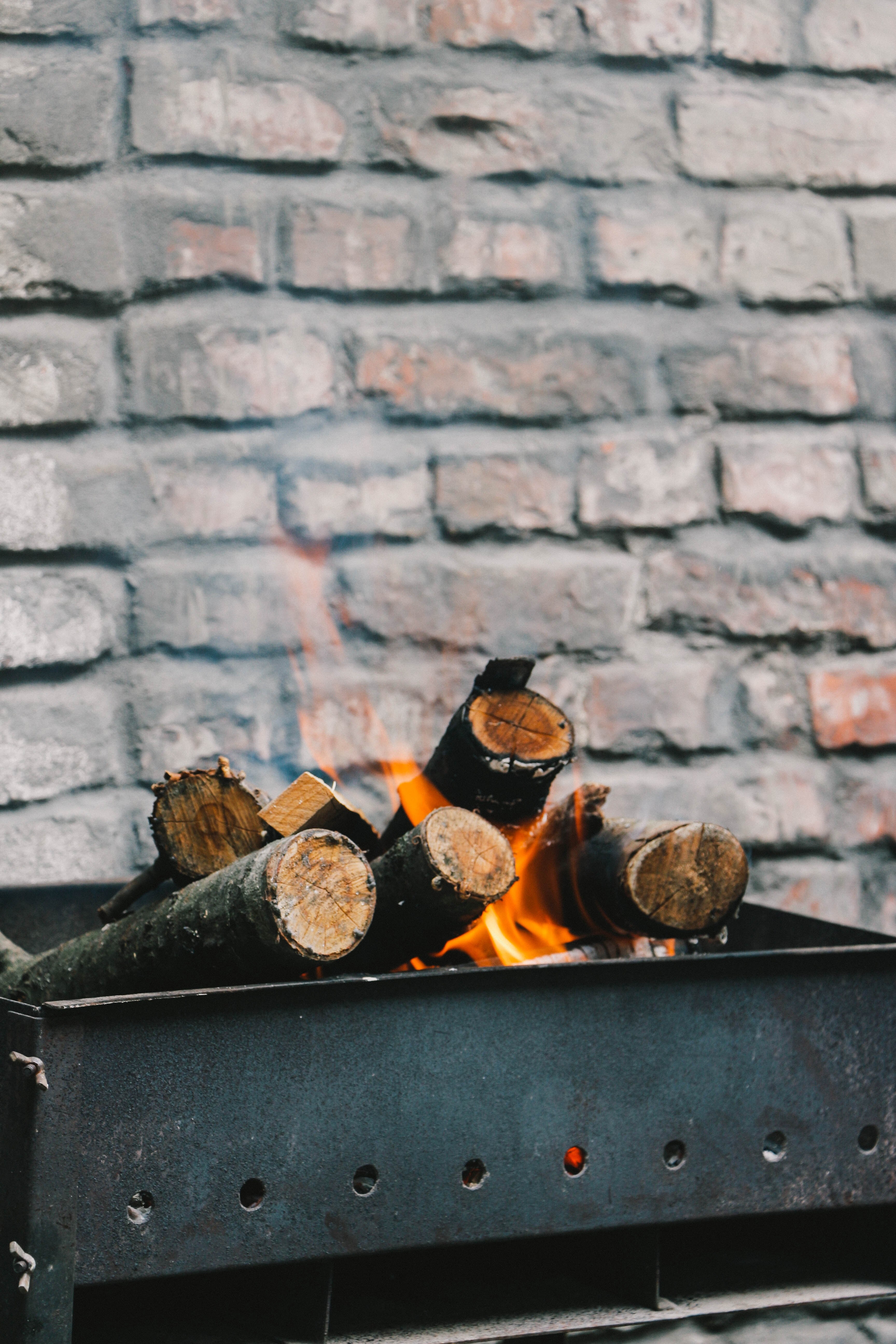 burning firewood in a brazier next to a brick wall, flames in a brazier 4k, Phone HD Wallpaper