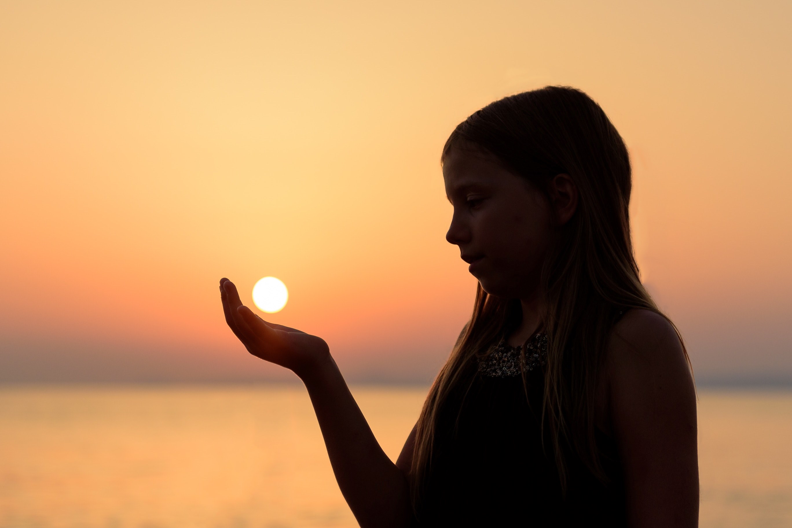 a woman in silhouette appears to hold the setting sun in her hand in koundouros, holding the sun 4k, HD Wallpaper