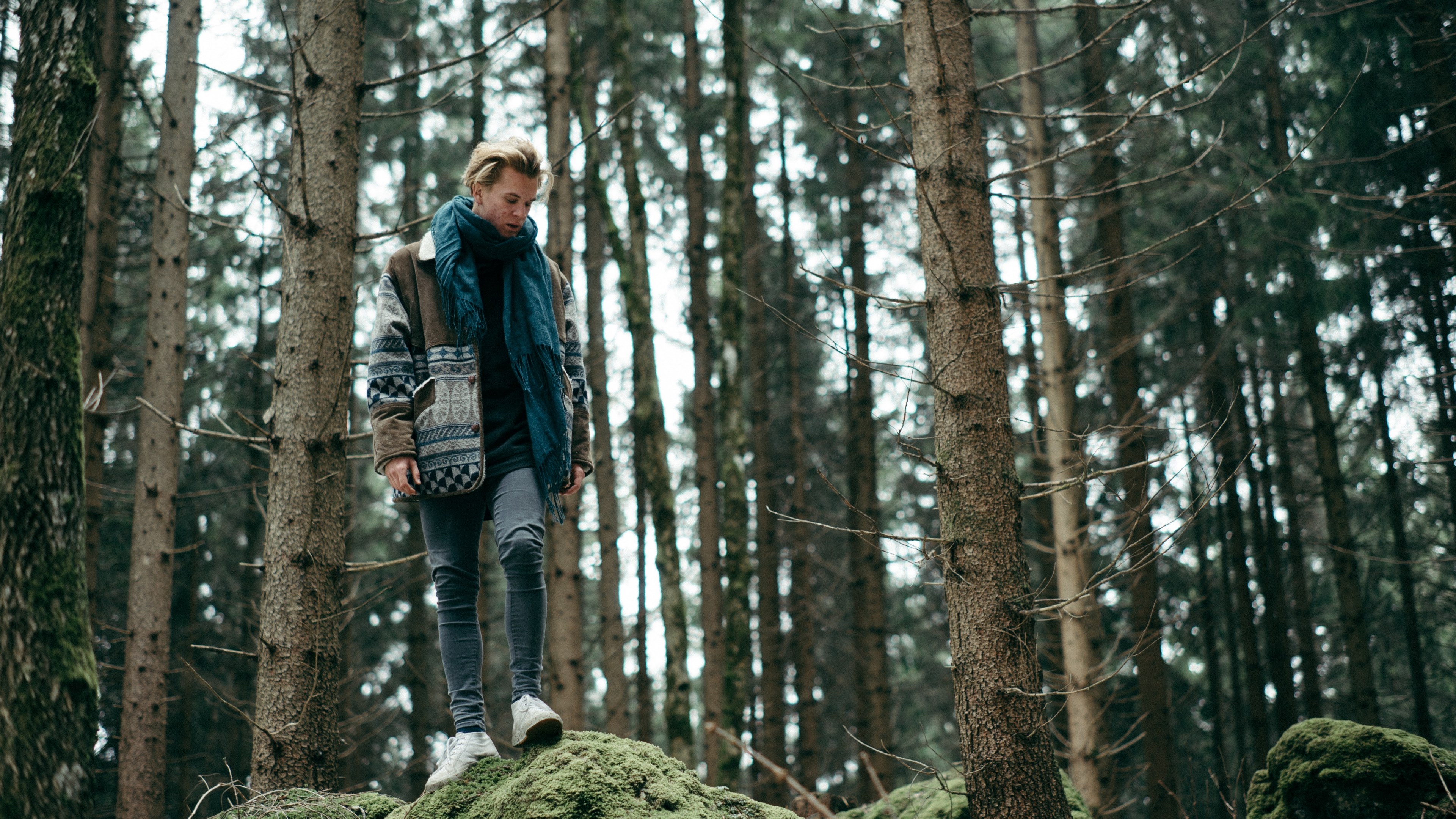 a young man standing on a mossy rock in a coniferous forest, bohemian man on a mossy rock 4k, HD Wallpaper