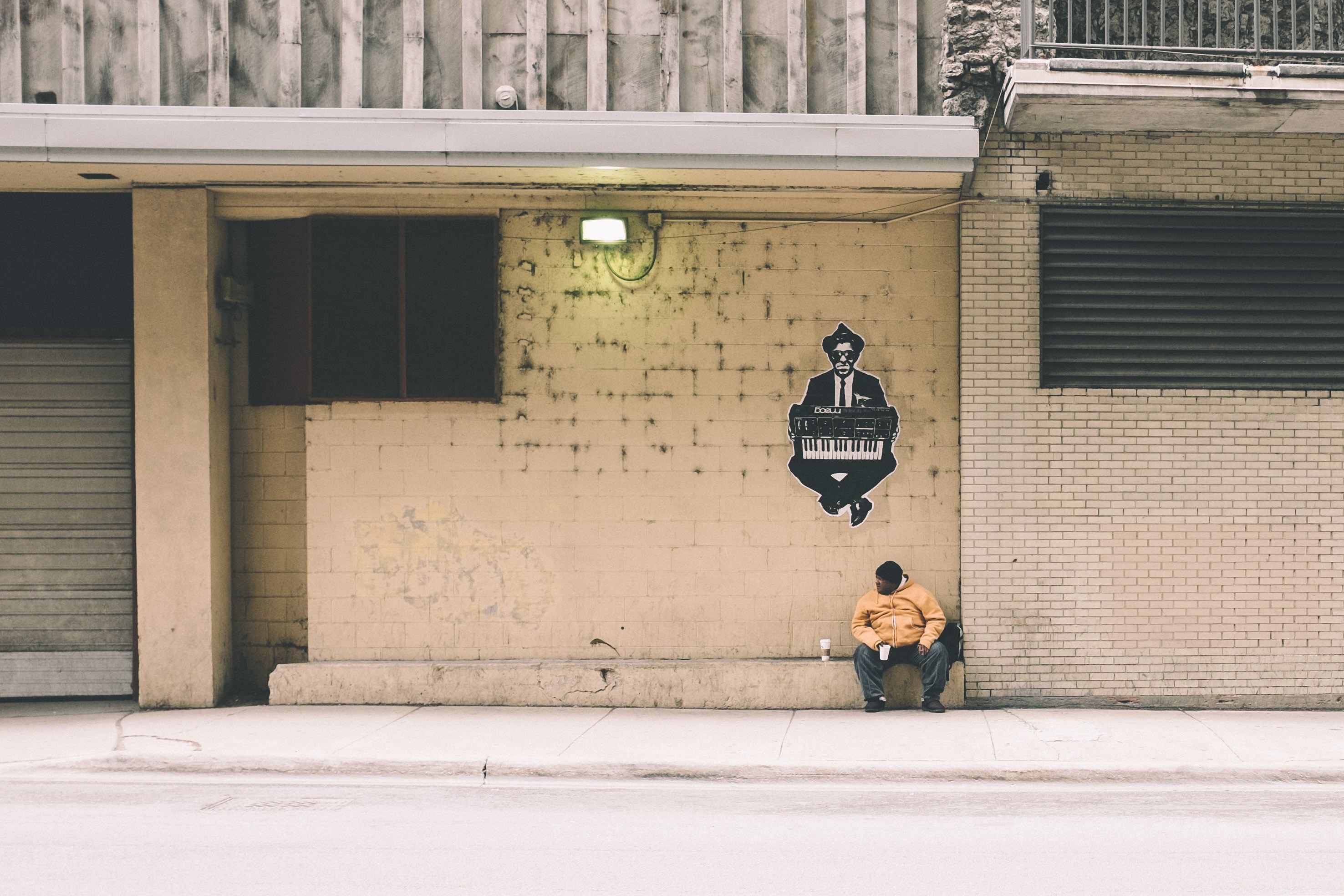 a man with a cup of coffee sitting on a ledge in the wall on an empty street, drinking coffee on empty street 4k, HD Wallpaper