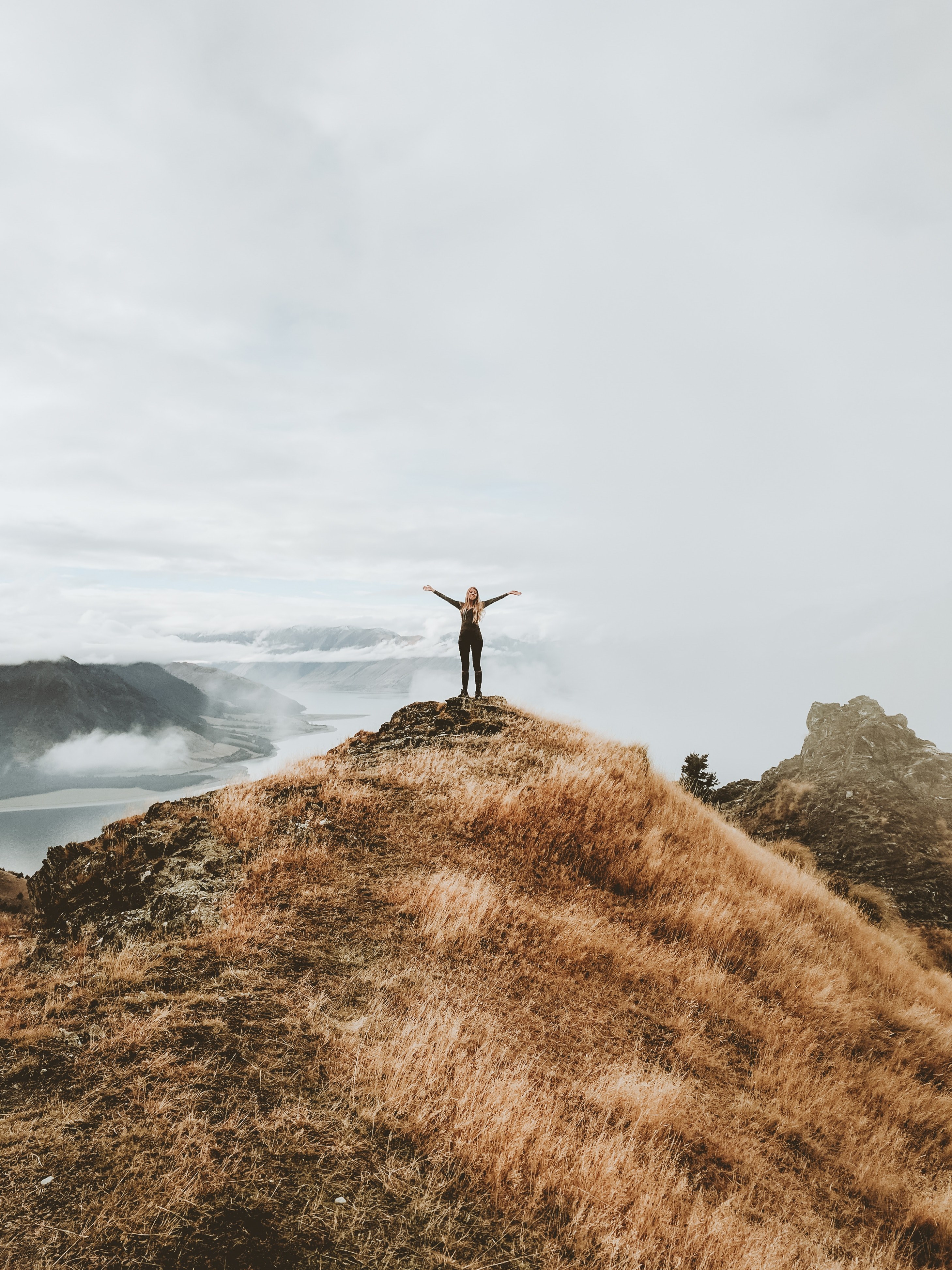 a woman standing on a cliff with her arms spread open, _standing edge cliff 4k, Phone HD Wallpaper