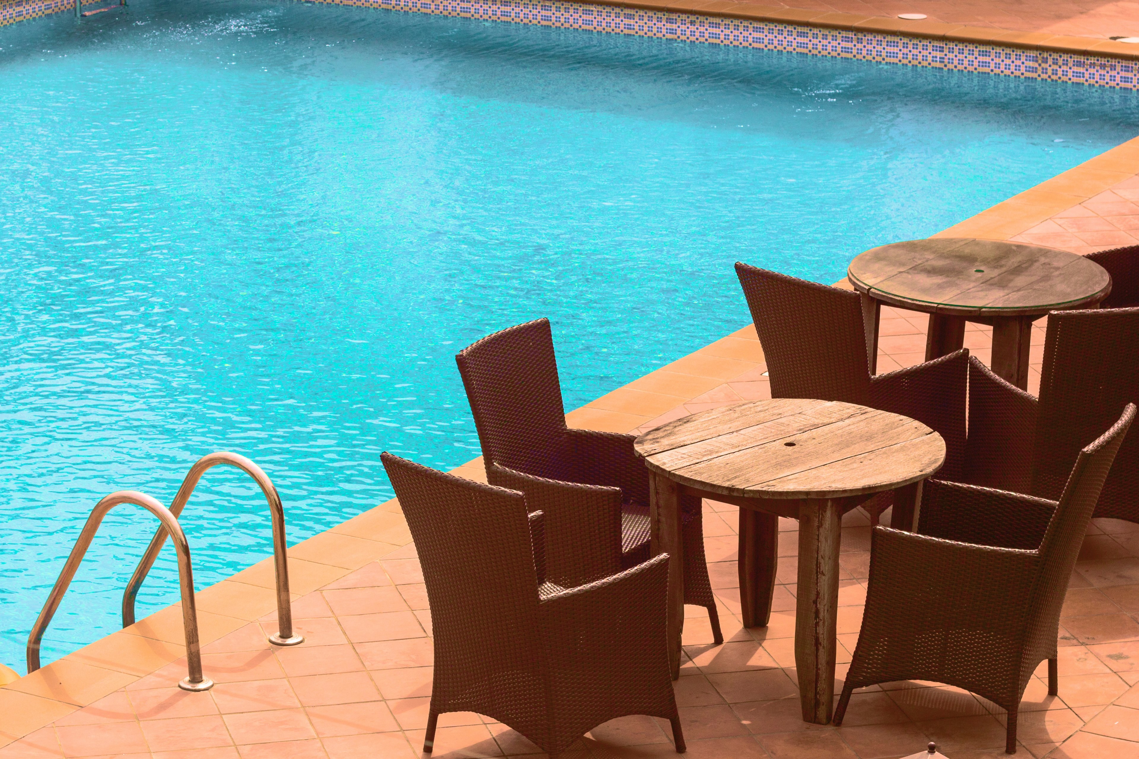 rattan chairs around small wooden tables by a pool, chill out_ its morning 4k, HD Wallpaper
