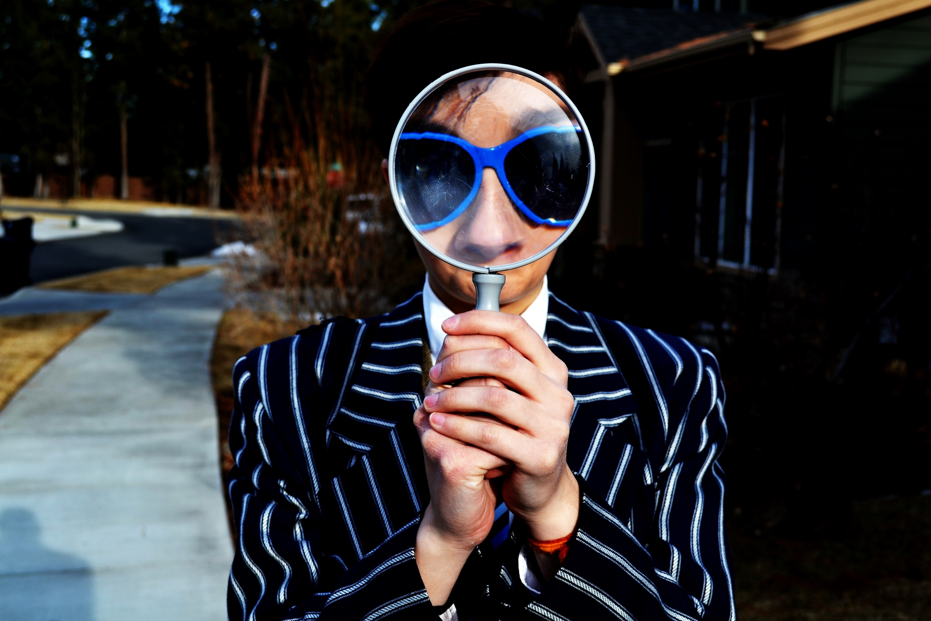 a person holding a magnifying glass wearing a striped suit and blue sunglasses in bend, bend man 4k, HD Wallpaper