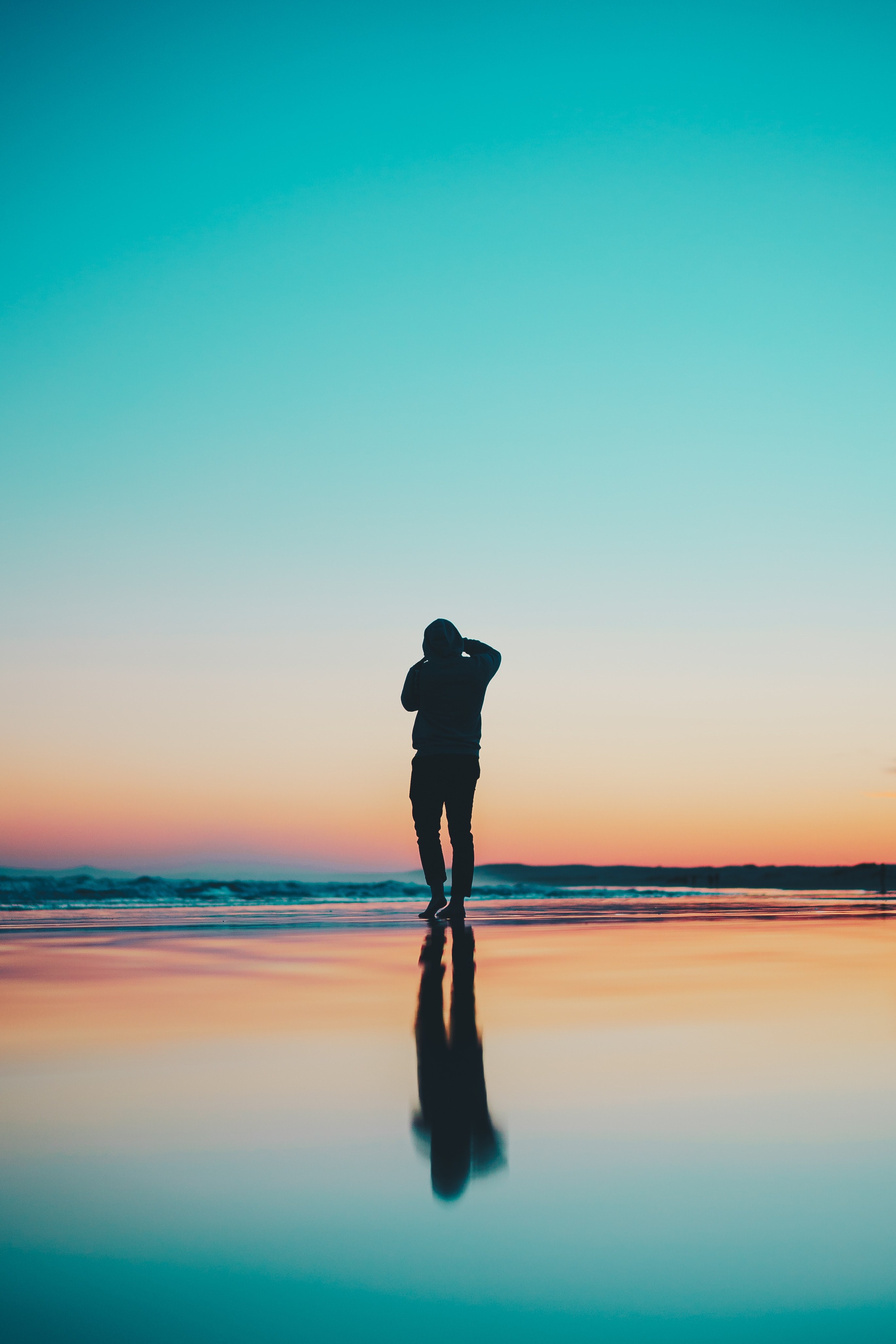 a man standing on the water at stockton beach with the sunset in the background, reflection of a silhouette 4k, Phone HD Wallpaper