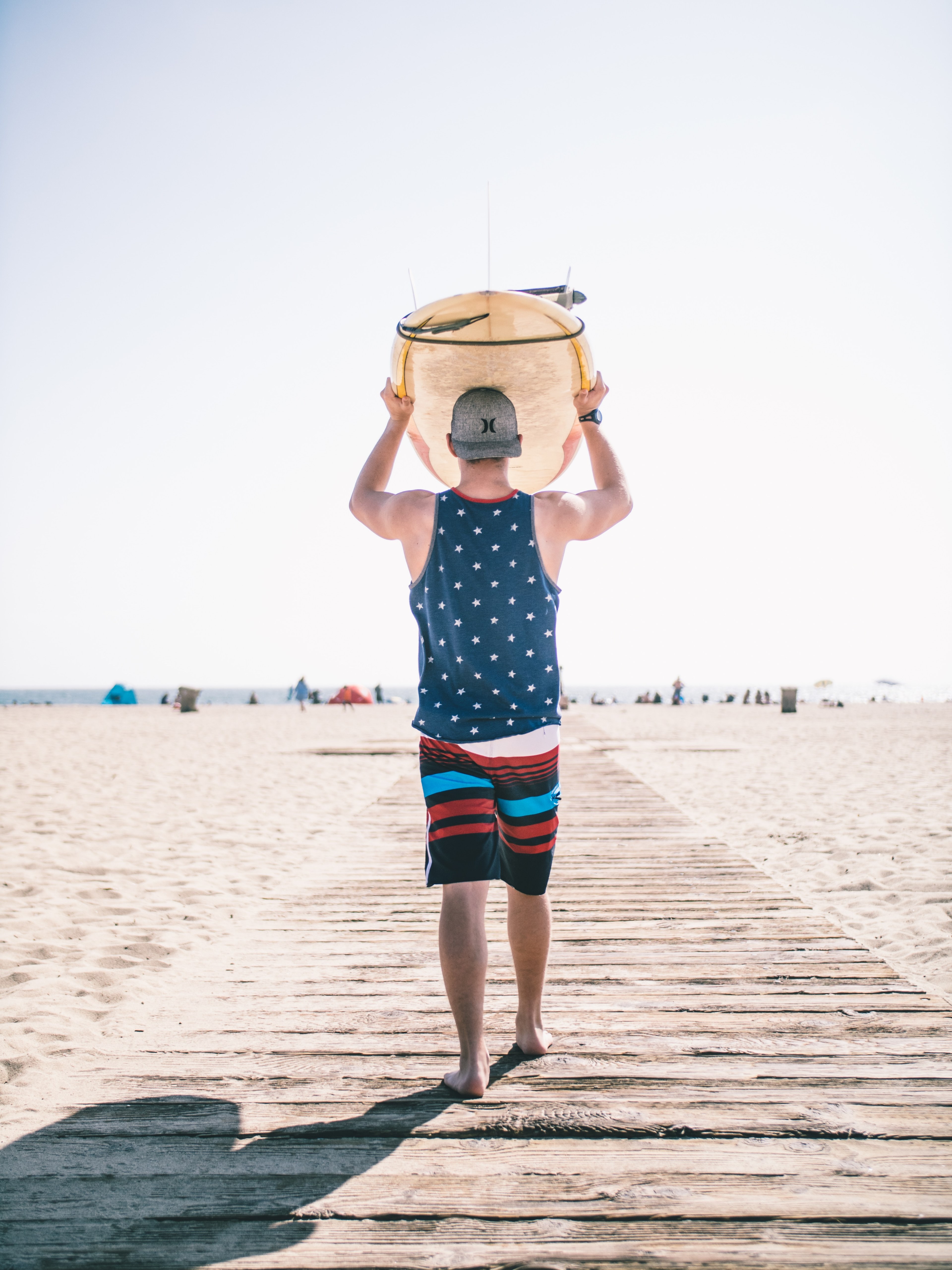 a man holds an object on his head as he walks down santa monica beach, surf ready 4k, Phone HD Wallpaper